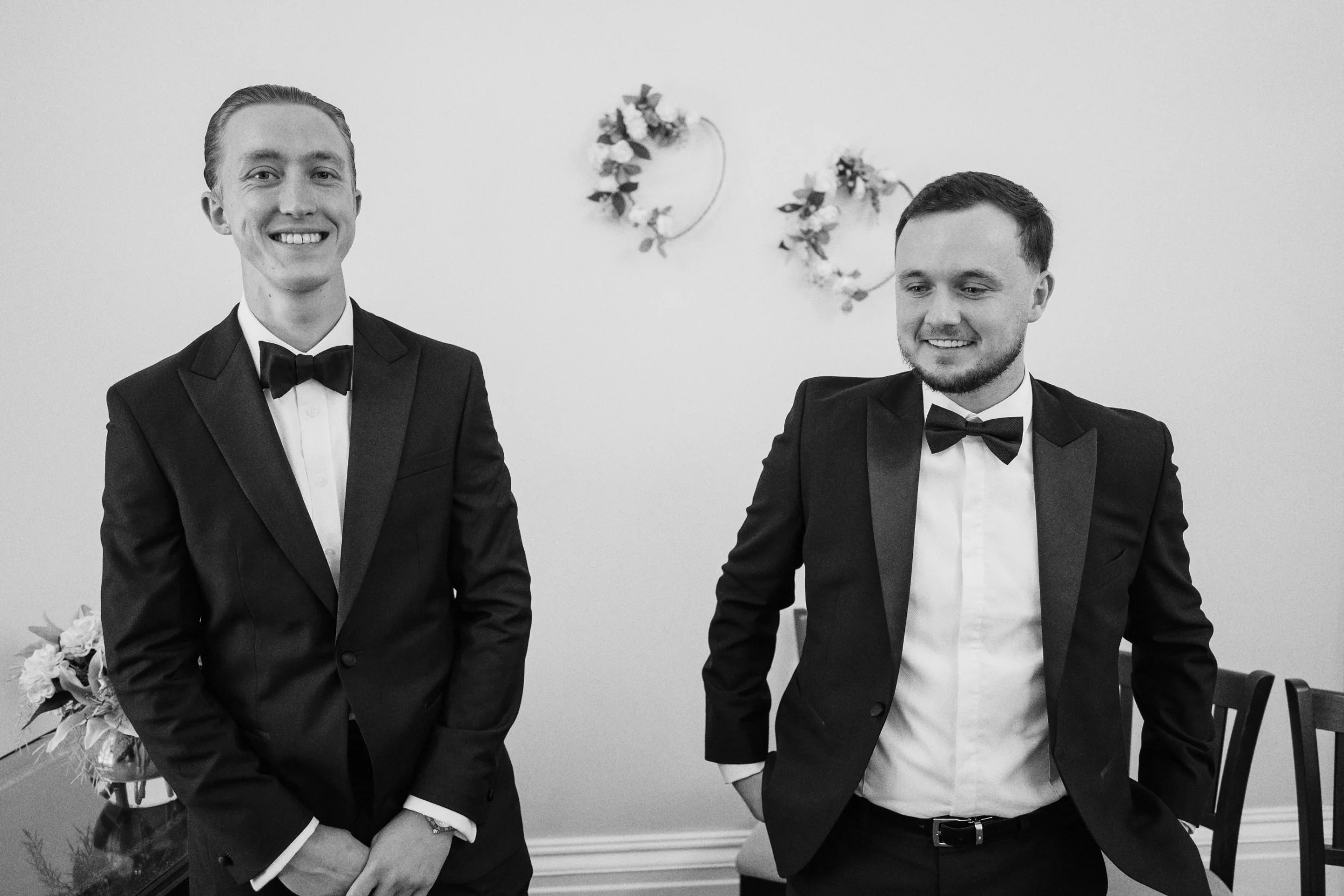 Groom and his best man smile at the wedding photographer as they wait for the bride to arrive at the Surrey wedding venue