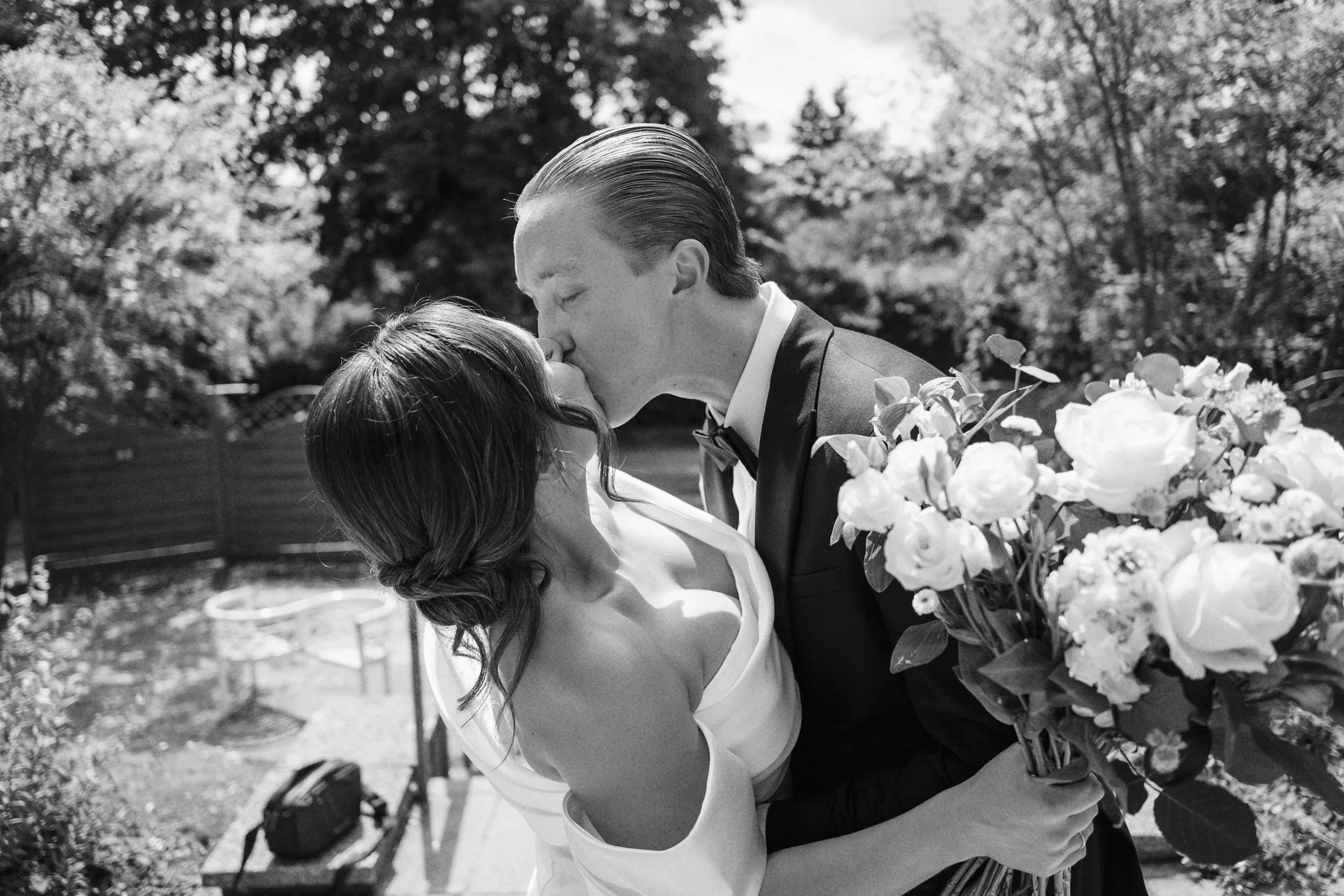 Bride and groom kiss as the photographer takes their wedding photos outside the Surrey wedding venue