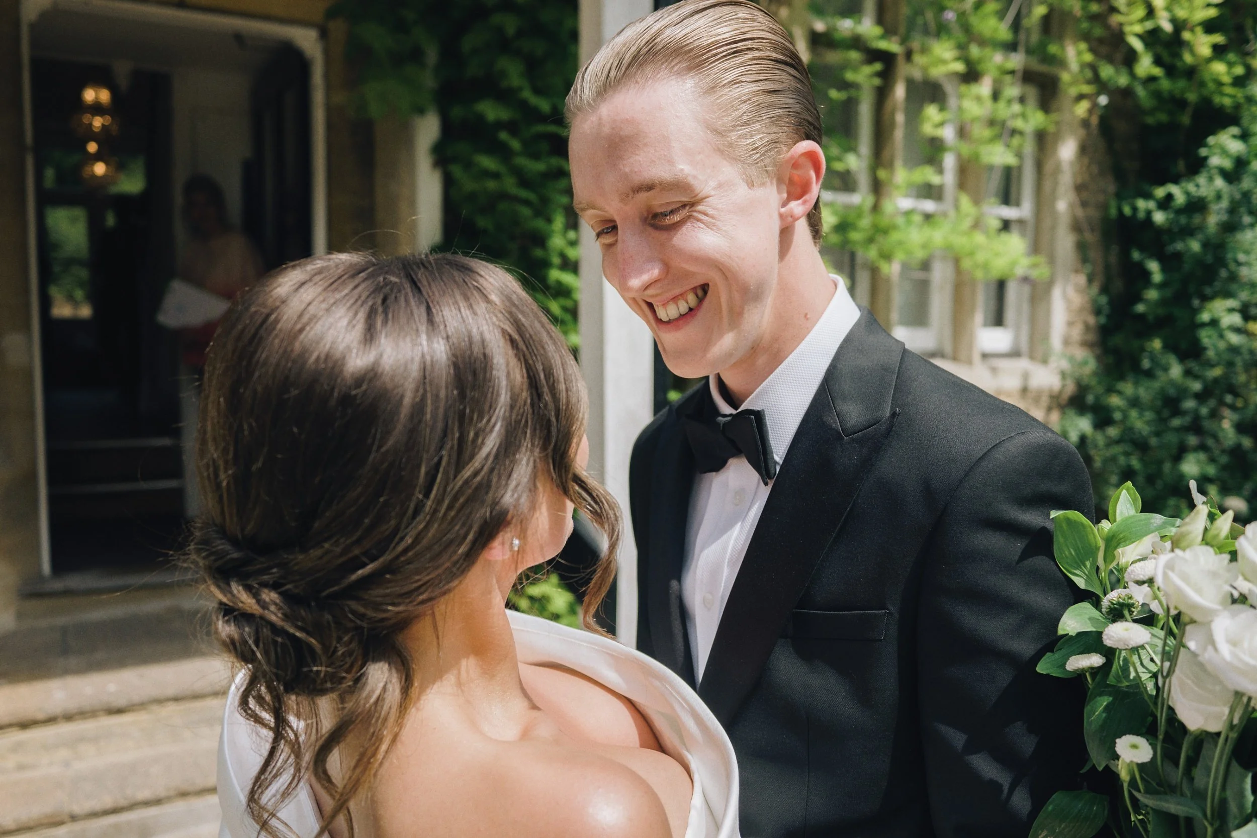 Bride and groom smile at each other as the wedding photographer captures their natural wedding photos after their ceremony in Guildford