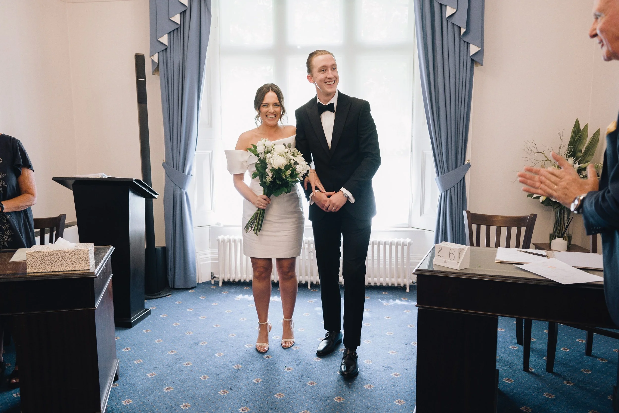 Bride and groom leave the ceremony room at Guildford Register Office, Surrey