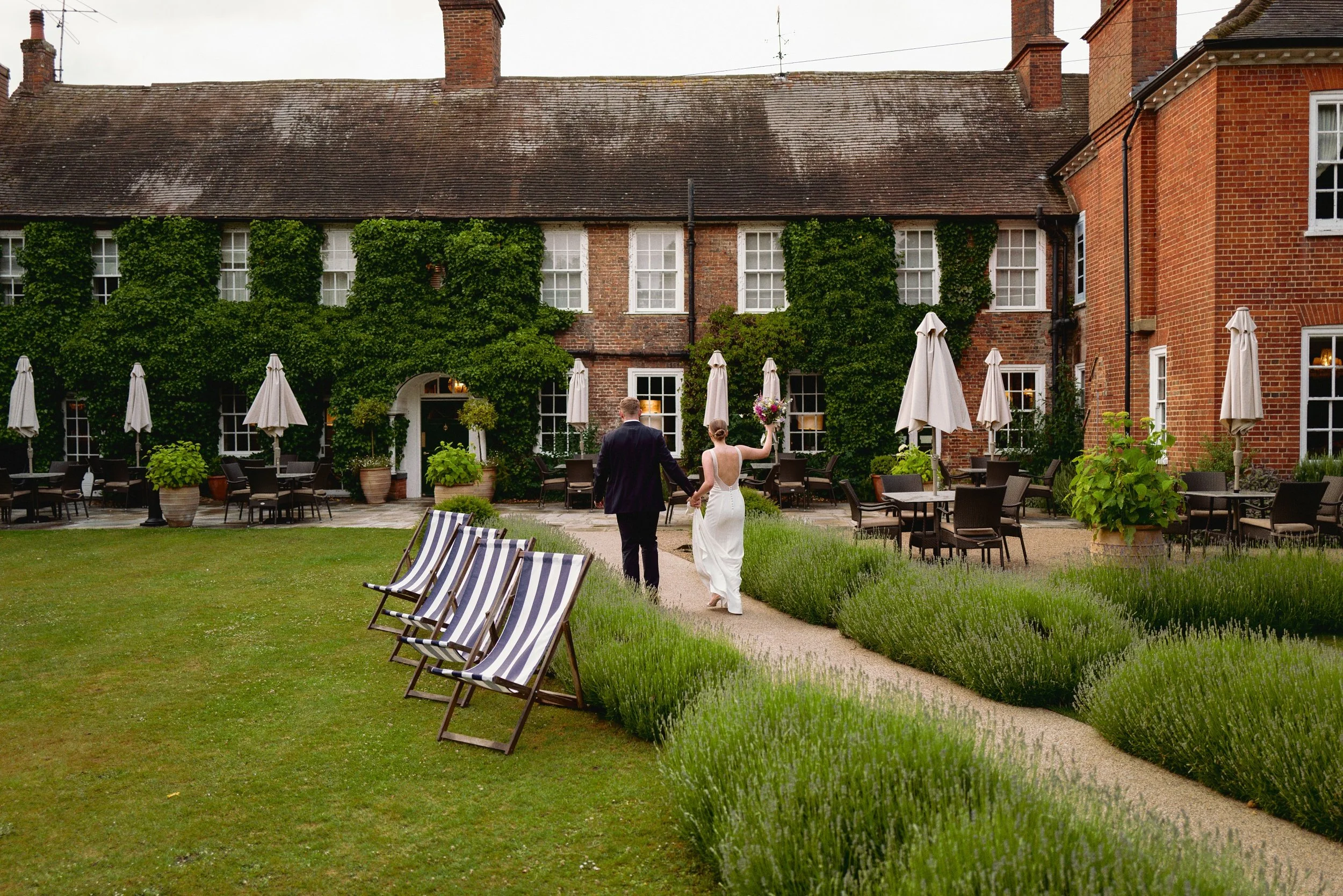 Couple walking into the Bush Hotel Farnham on their wedding day