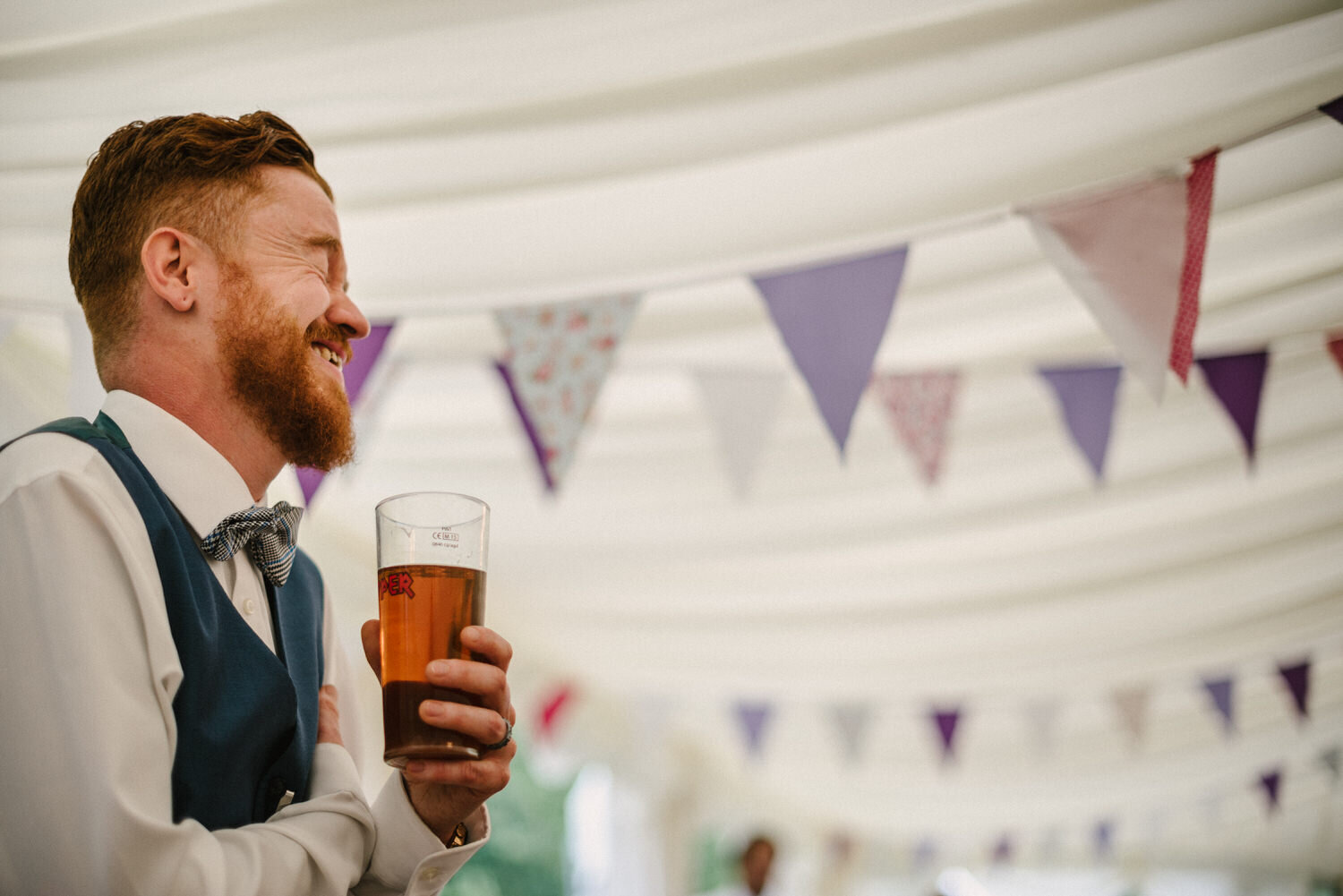 Groom laughs during speeches at Surrey wedding