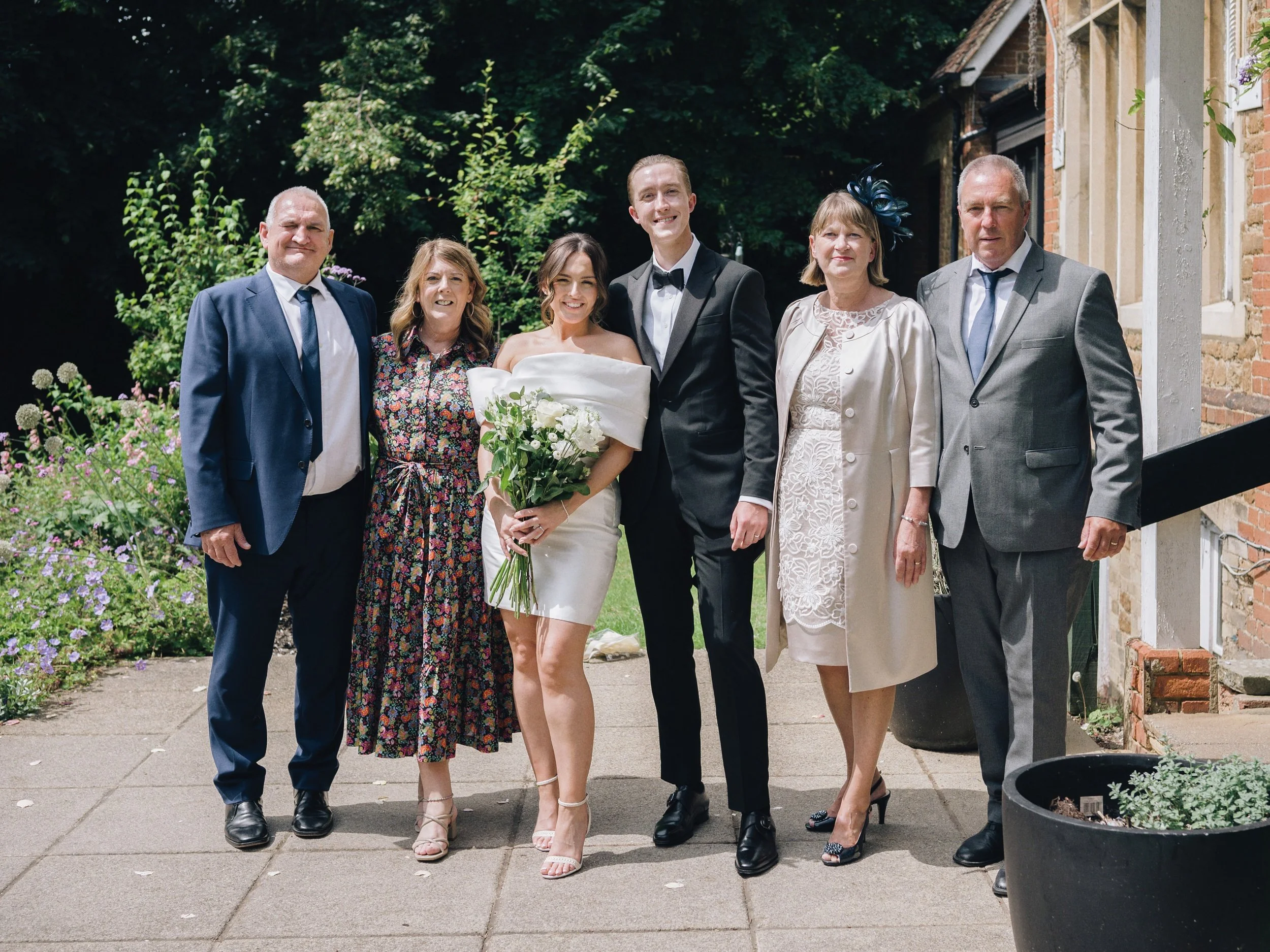 Family photo with the bride and groom outside the Surrey wedding venue
