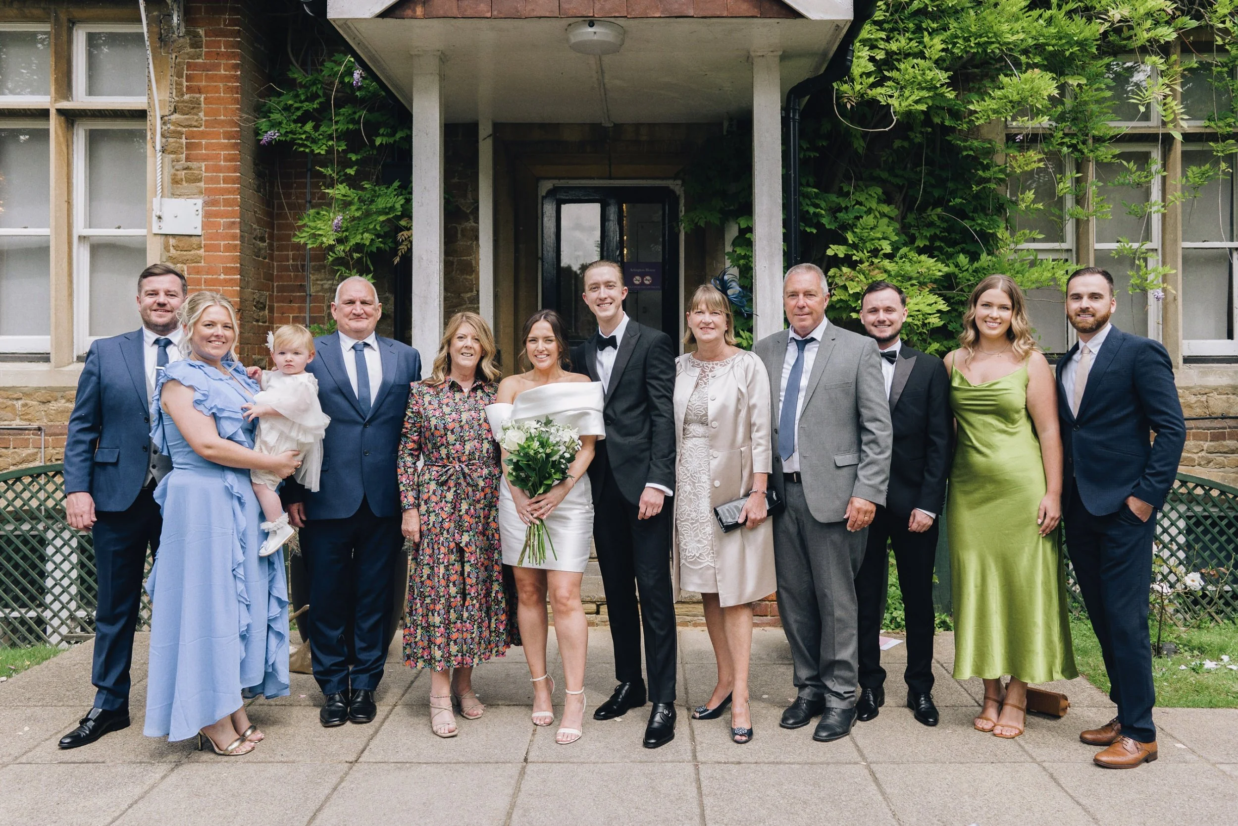 Wedding guests gather outside Guildford Register Office in Surrey as the photographer takes a group photo of them