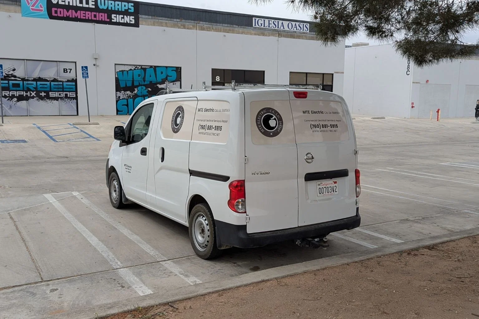 A white MTE Electric commercial service van parked in a business plaza, providing professional electrical repairs and installations for Phelan businesses.