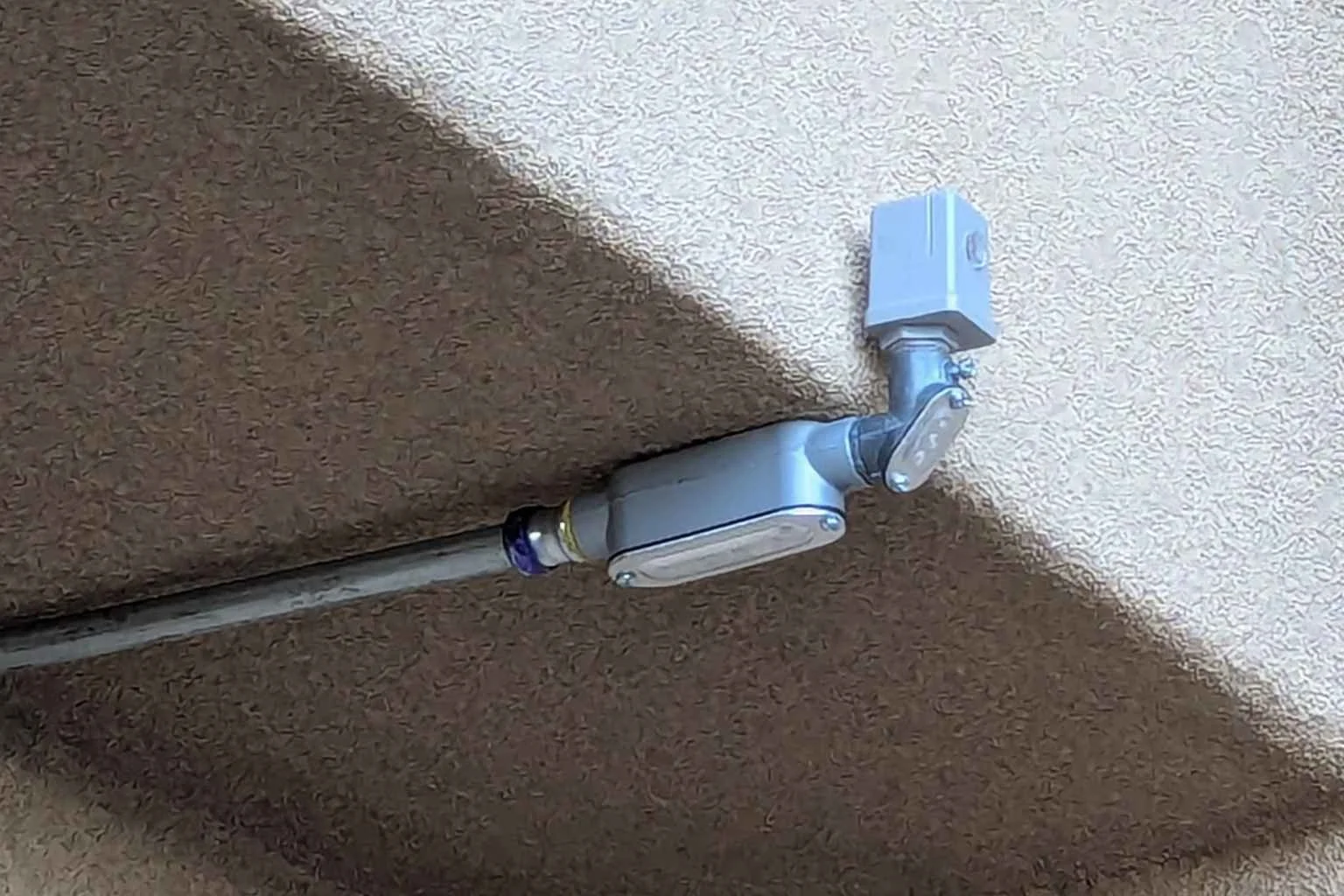 Photocell lighting control installed on a commercial building in Phelan, California, providing automatic dusk-to-dawn control for bank parking lot and exterior lighting.