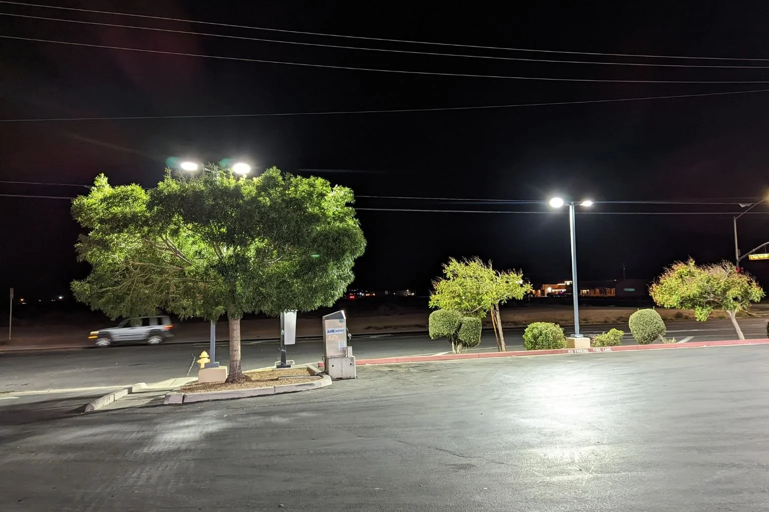 Brightly illuminated commercial parking lot at a local Apple Valley service station after an LED lighting retrofit completed by MTE Electric.