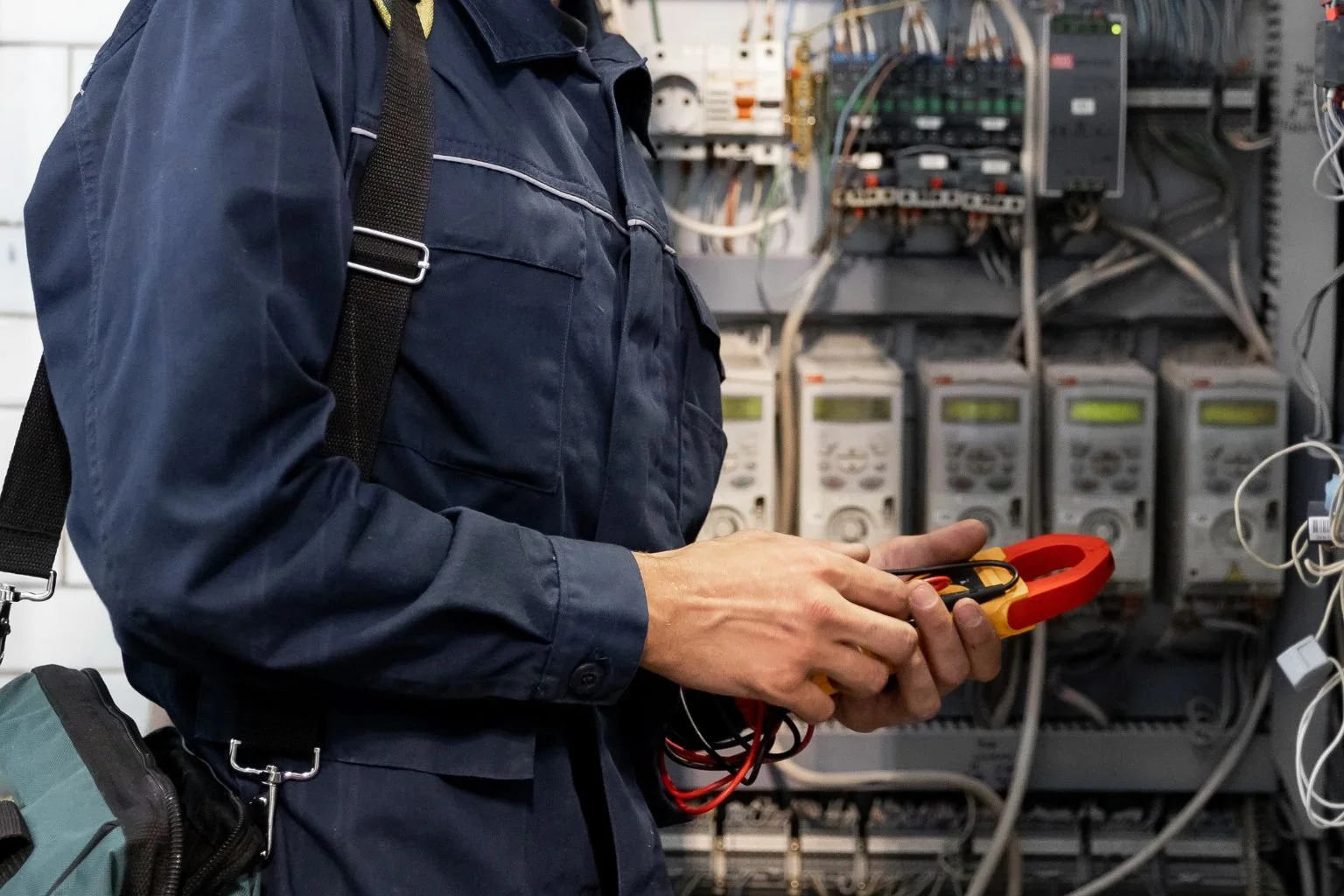 Electrician with an electrical tester.