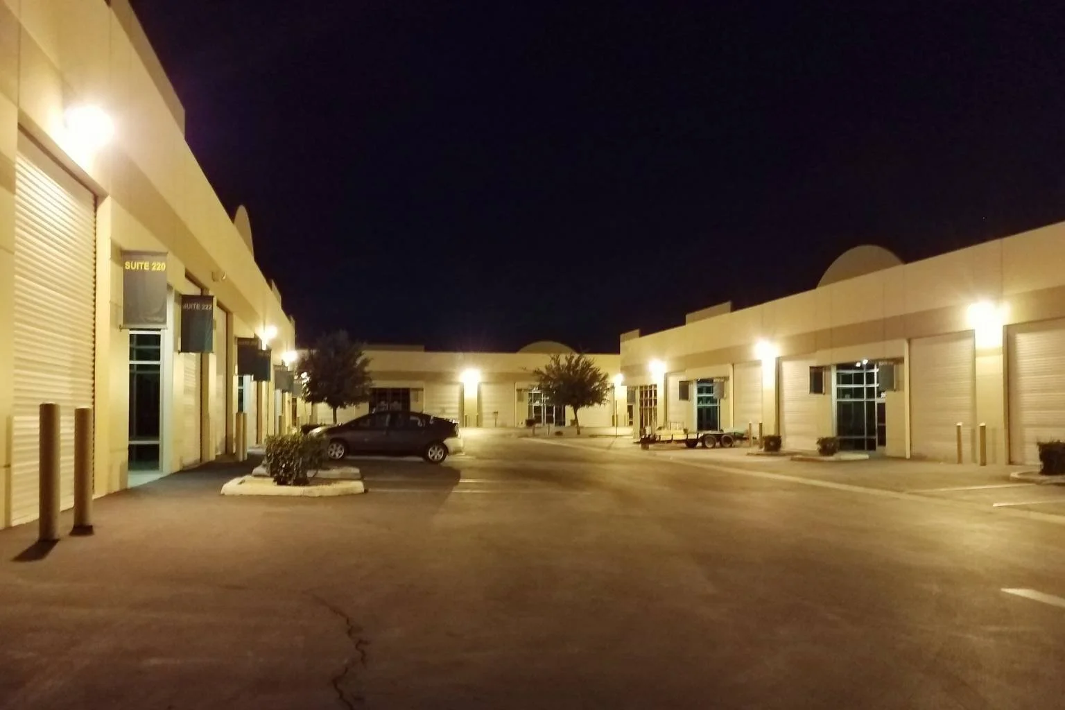 Commercial exterior lighting illuminating a business center and parking area at night in the California High Desert.
