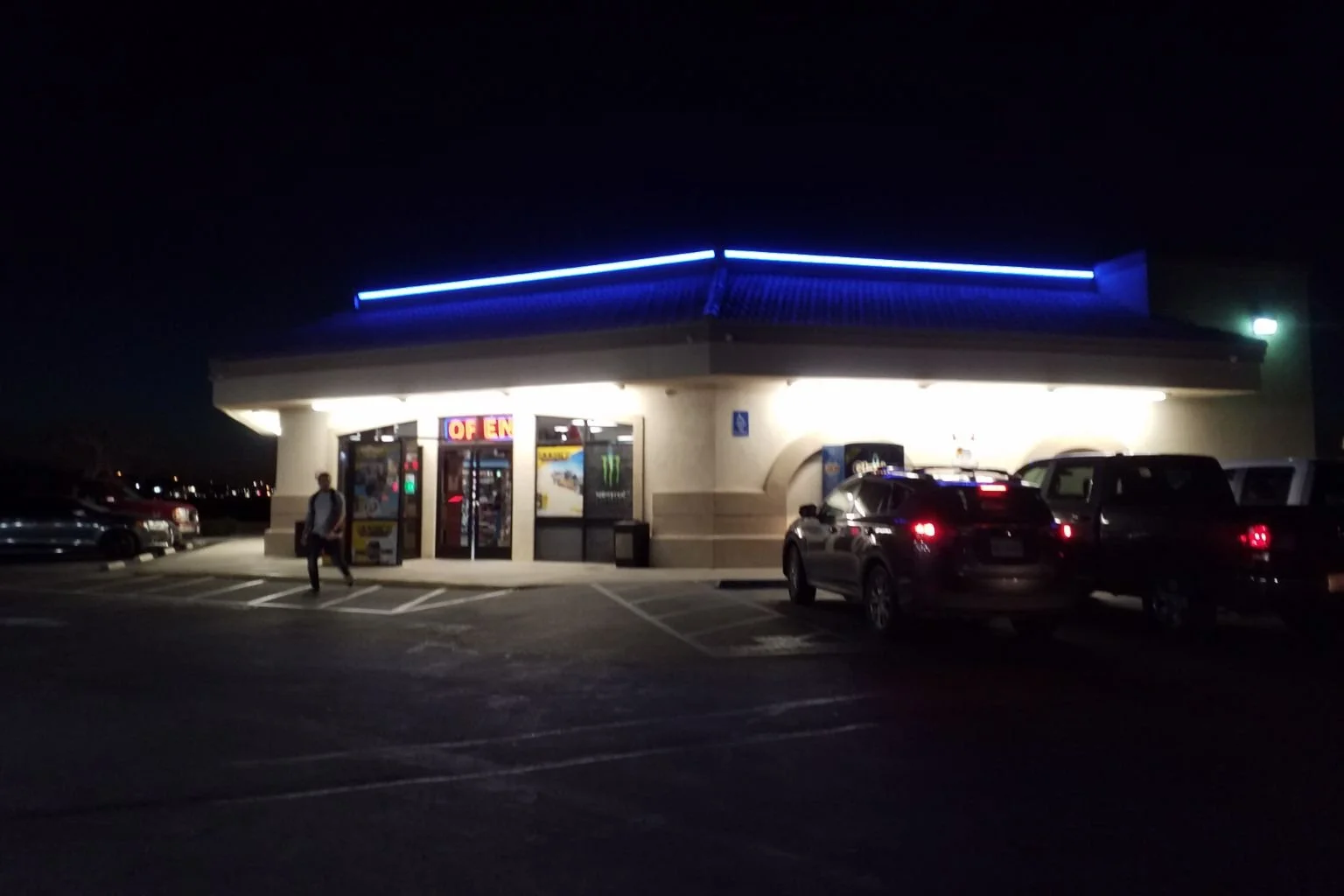 Chevron gas station convenience store in Apple Valley, California with blue LED accent lighting installed along the roofline at night.