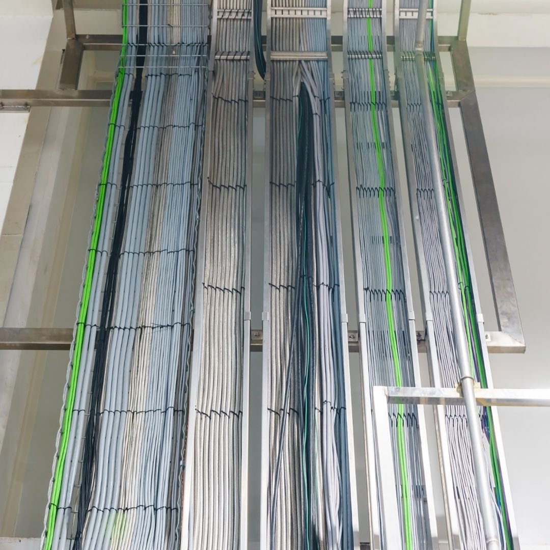 Structured communication and data cabling neatly organized in overhead cable trays for a professional network installation.