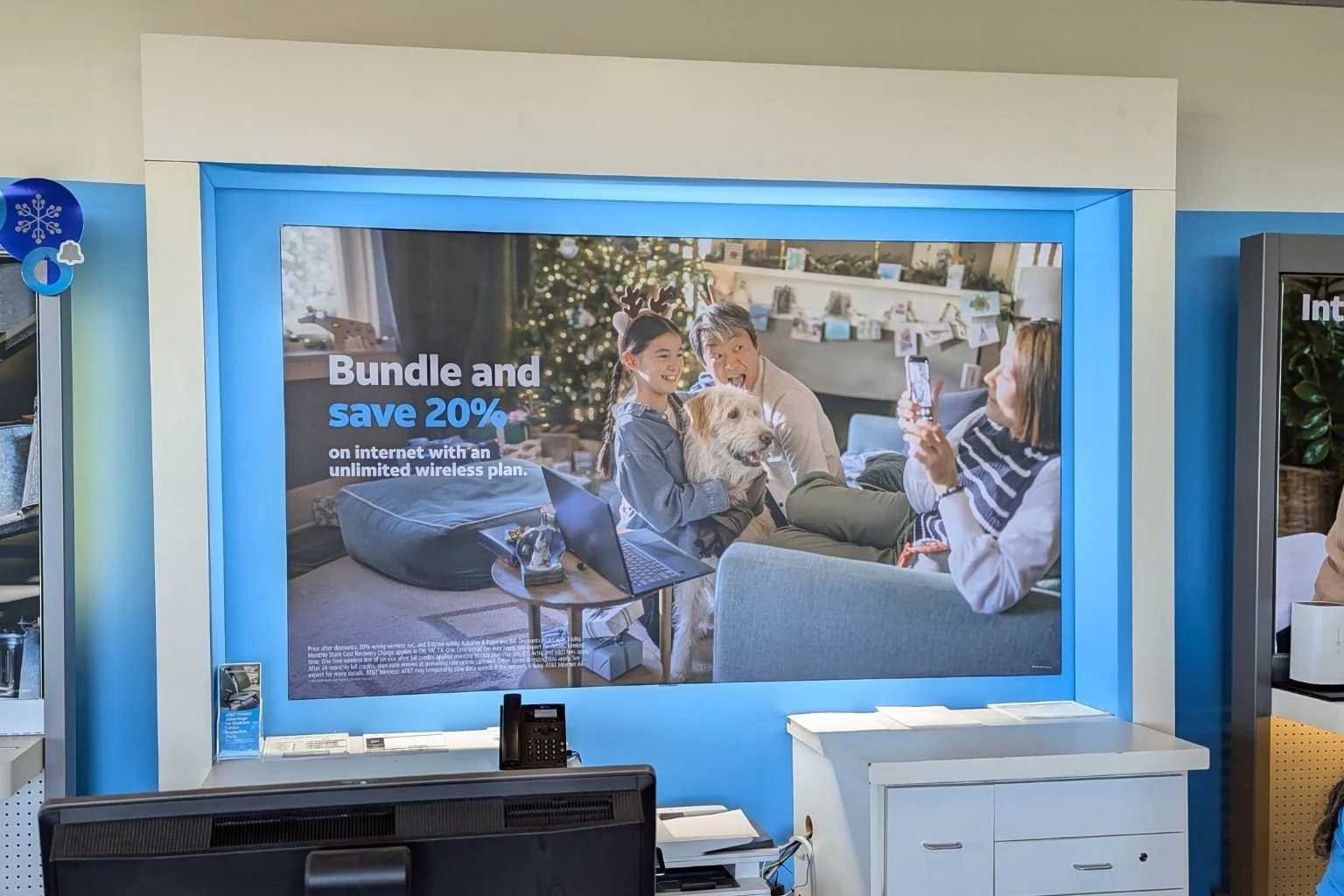 Electrician-installed LED ribbon lighting upgrade replacing fluorescent lamps on a merchandise display wall inside a cellphone store in Lancaster, California.