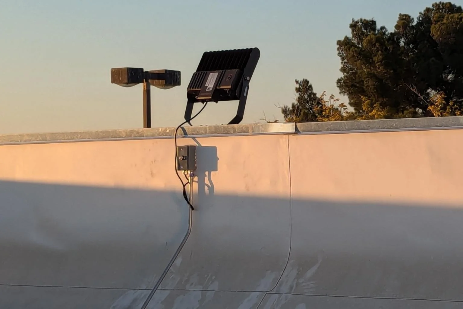 Backside view of an LED floodlight installed by MTE Electric on the roof of the Cycle Gear building in Victorville, CA, showing the mounted fixture and electrical connections used for commercial parking lot lighting.
