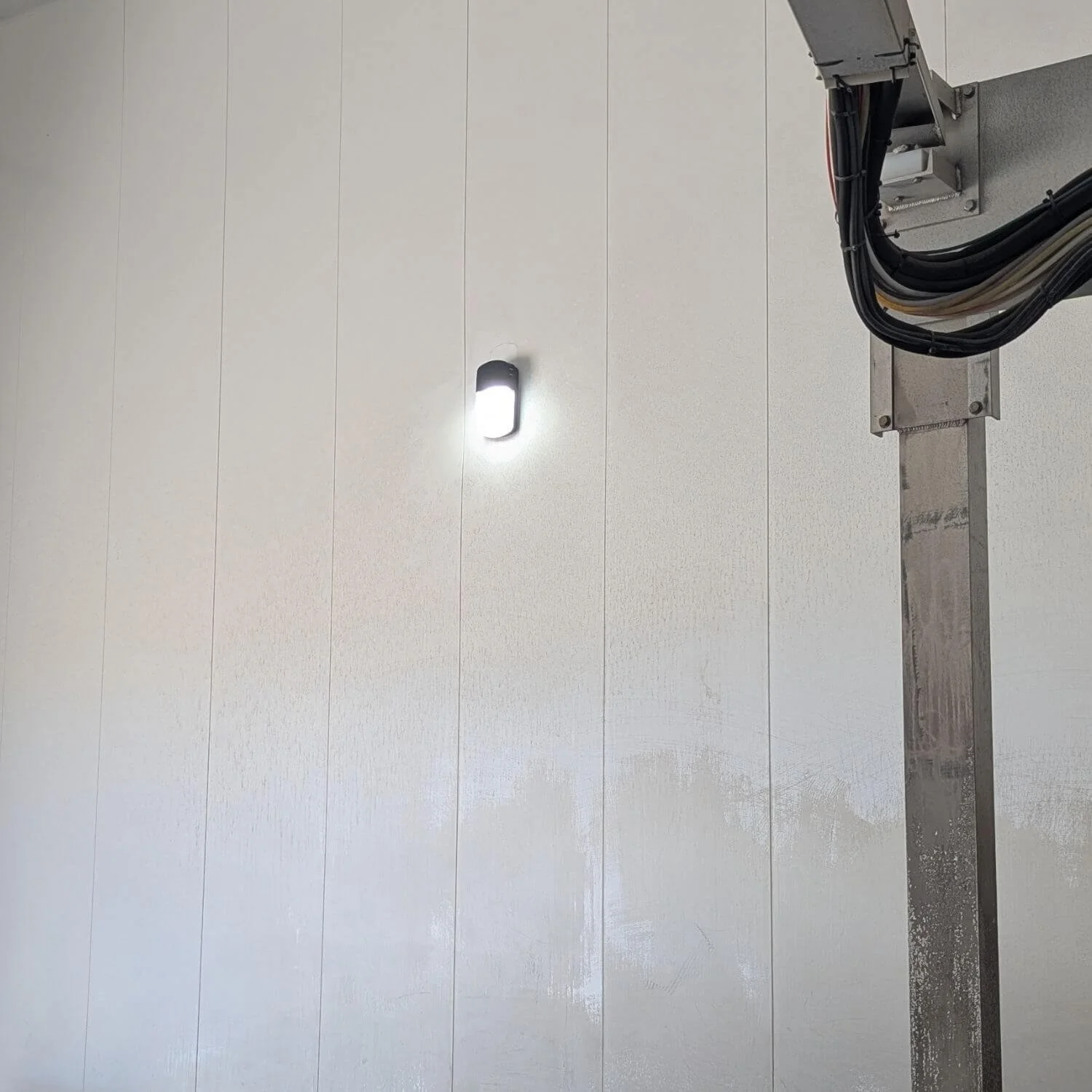 Close view of a new Lithonia LED wall pack operating inside the Beyond Food Mart car wash in Hesperia after replacement of the failed original fixture.