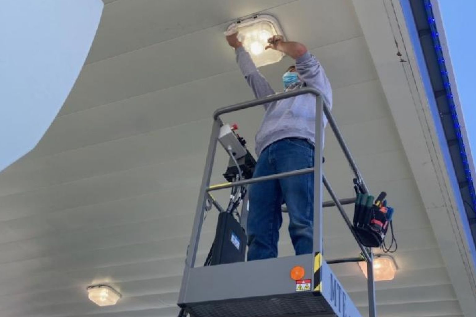 MTE Electric's electrician repairing a canopy light fixture at this Apple Valley service station.