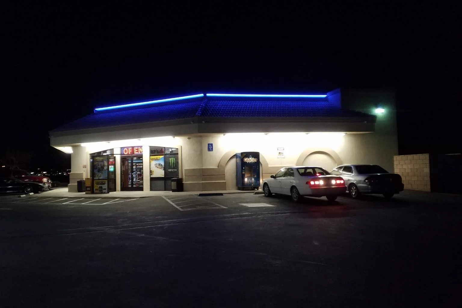 Exterior nighttime view of a local Apple Valley, California service station with new blue LED architectural roof lighting installed after replacing old neon lighting.