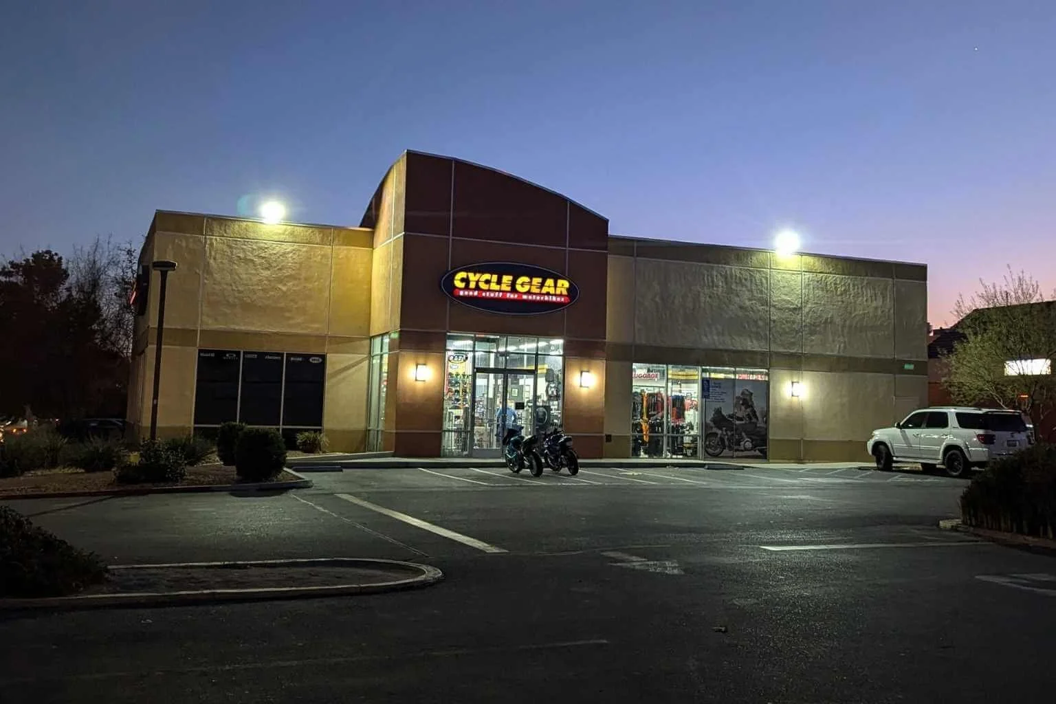 Commercial electrician in Victorville installing LED flood lights to improve parking lot lighting and illuminate the front of a retail building, increasing visibility and customer safety after dark.