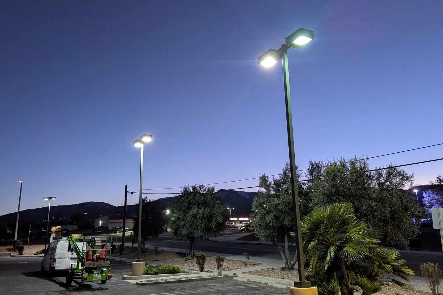 MTE Electric service truck on-site in Phelan, California, converting traditional parking lot pole lights to energy-efficient LED fixtures for a local commercial property.