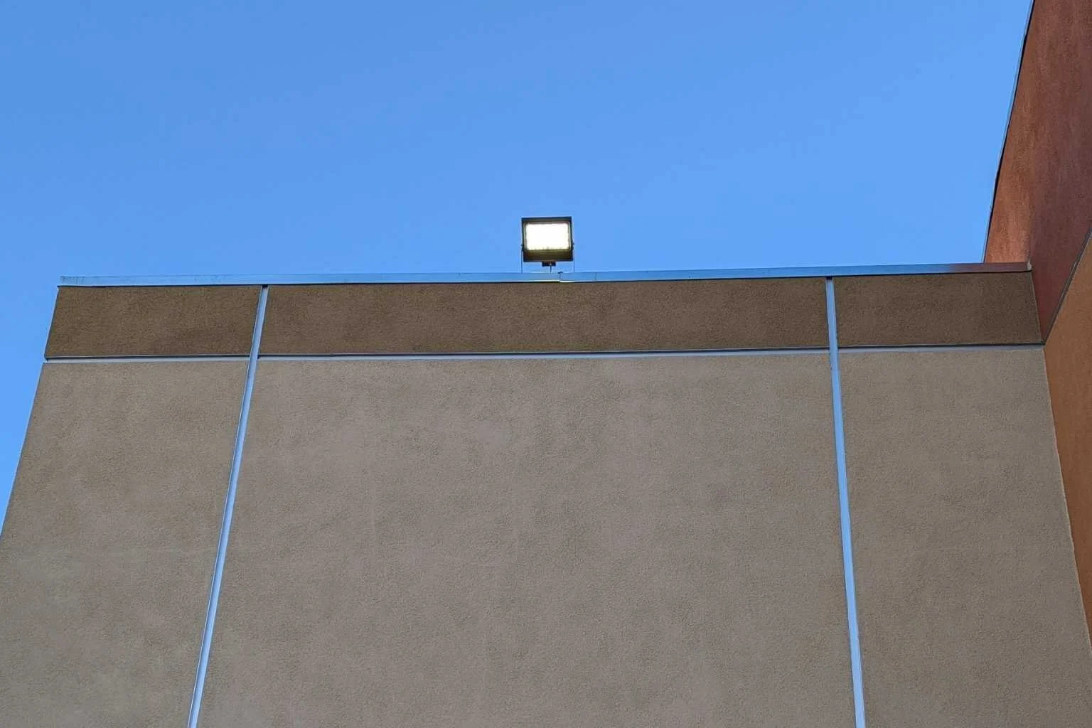 New LED exterior flood light installed above the roofline at Cycle Gear in Victorville, California, providing improved parking lot illumination for the commercial building.