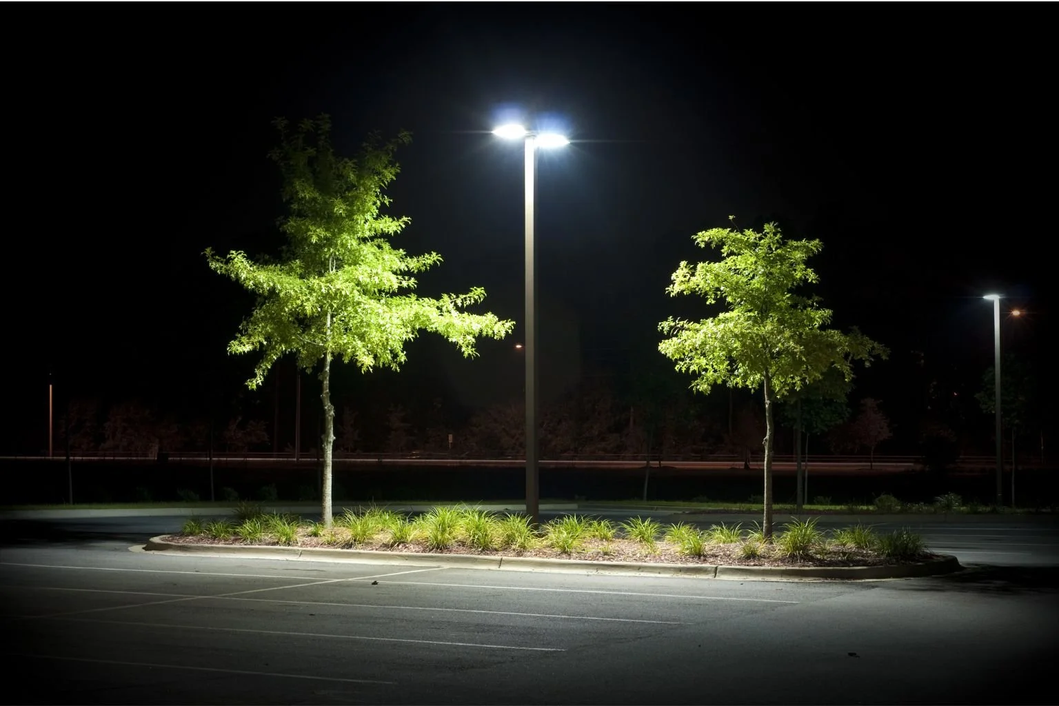 Bright parking lot lighting illuminates an empty lot at night, professionally installed by an Apple Valley electrician.
