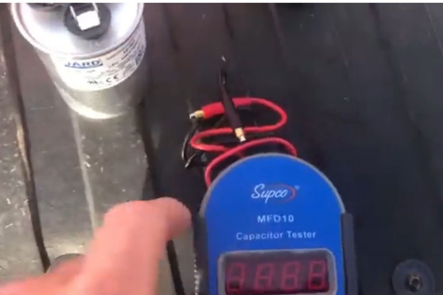 Electrician testing the capacitor for an electrical motor.