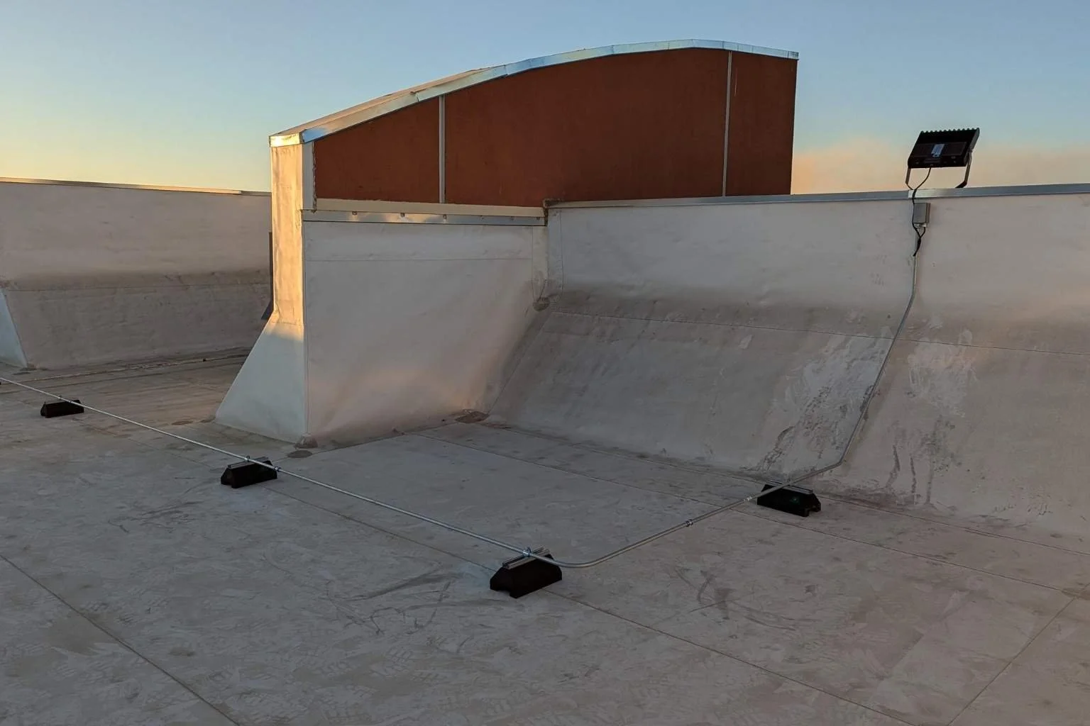 Electrical Metallic Tubing EMT conduit and commercial Westgate LED flood light installation on rooftop in Victorville California by MTE Electric.