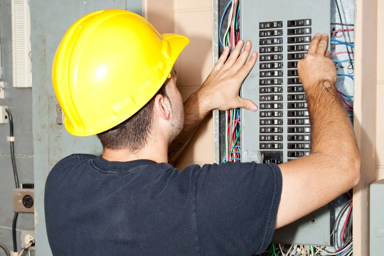 Electrician working inside electrical panel during maintenance in Victorville, Apple Valley, and Hesperia to safely service commercial electrical systems.