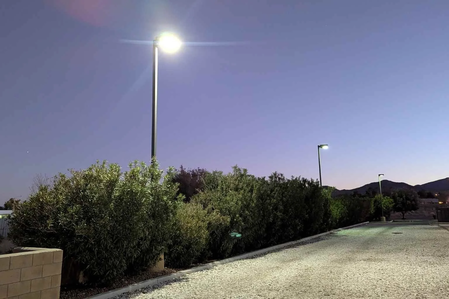 LED parking lot lighting illuminating the gravel rear access road behind Family Medical Center in Phelan, California, following a commercial parking lot lighting upgrade completed by MTE Electric.