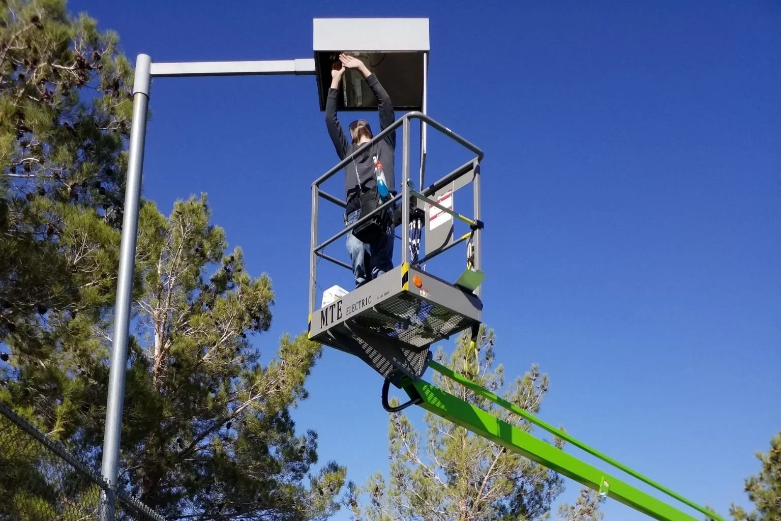 MTE Electric's electrician is converting an existing tennis court light fixture to LED in Victorville, California.