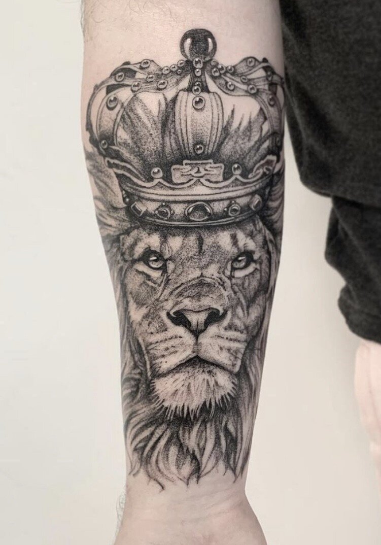 Grey shaded lion tattoo on upper sleeve