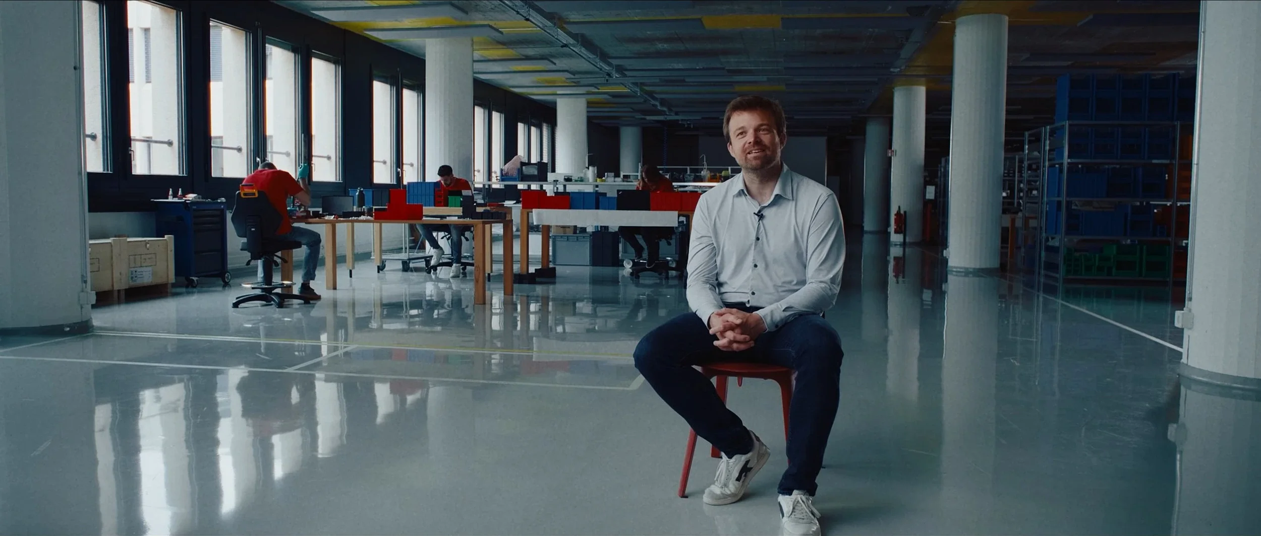 swissto12-branded-documentary-engineer-seated-factory-hall.webp