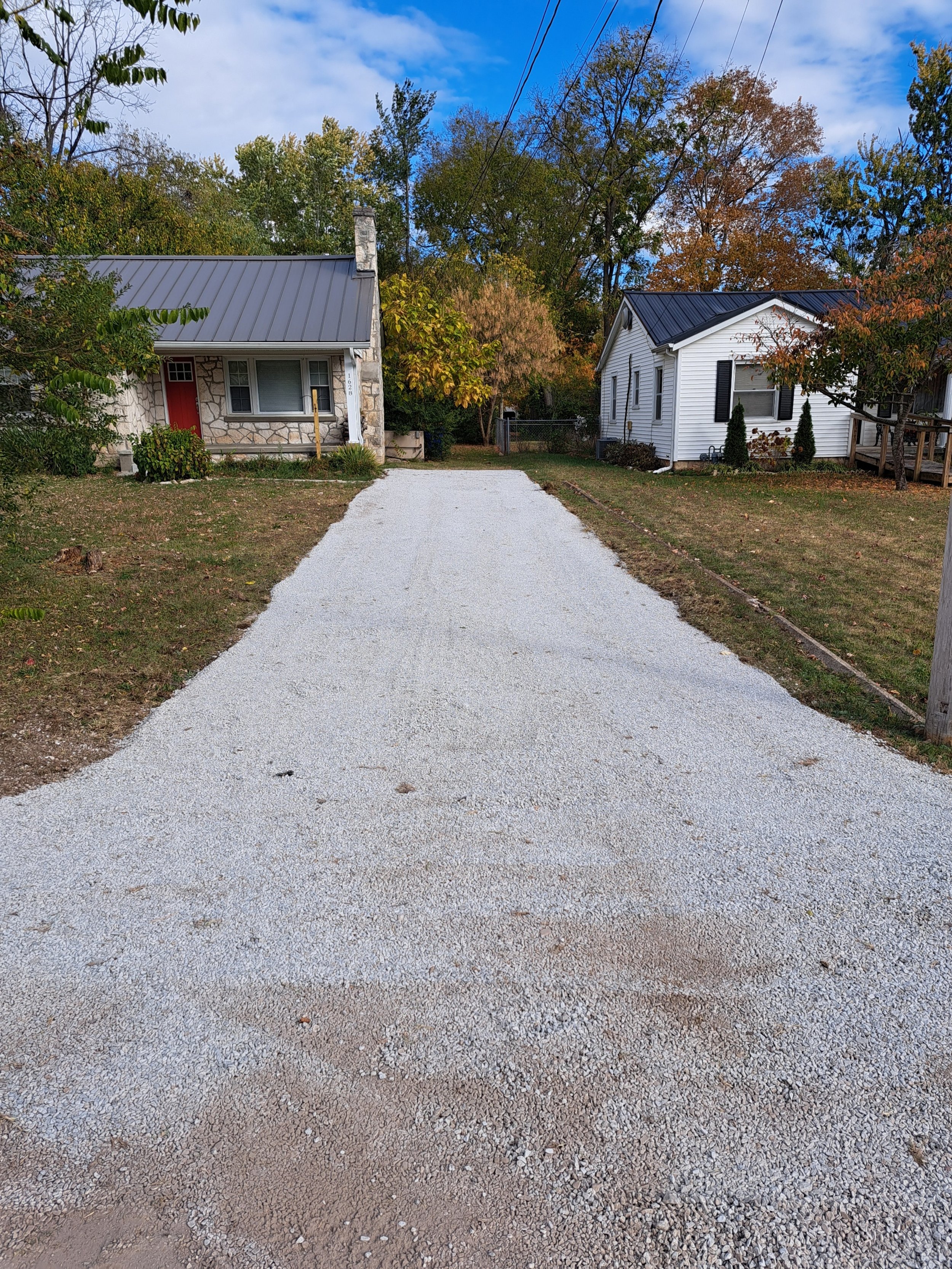 Excavating contractor doing finish grading of a gravel driveway