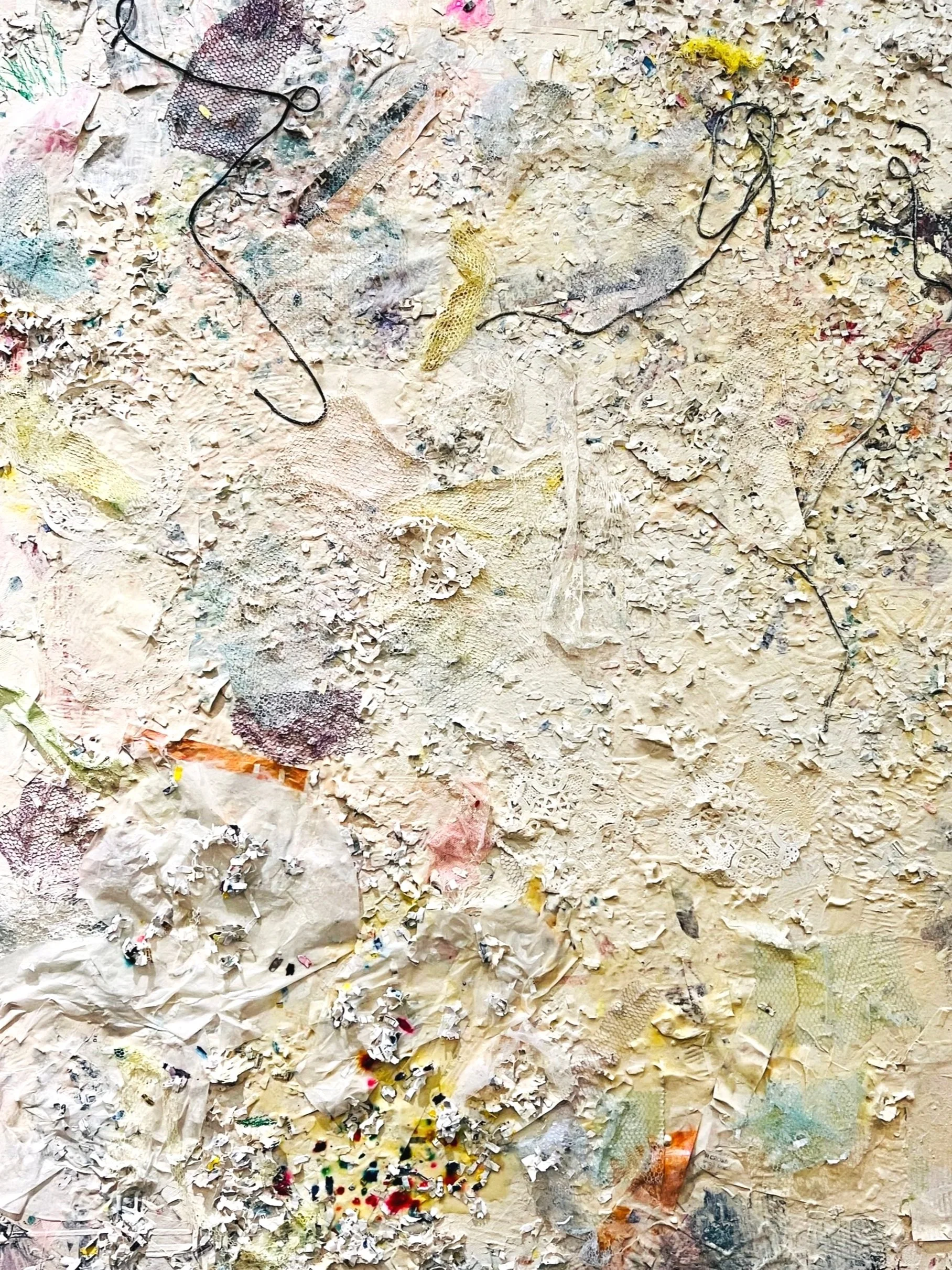 Close-up of textured artwork made from paper, string and fabric