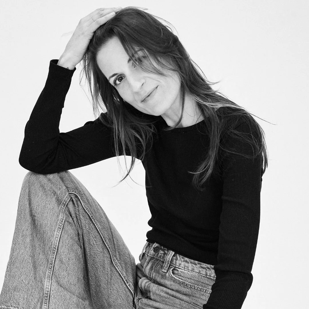 Schwarz weiß Bild einer Designerin, die auf einem Stuhl sitzt