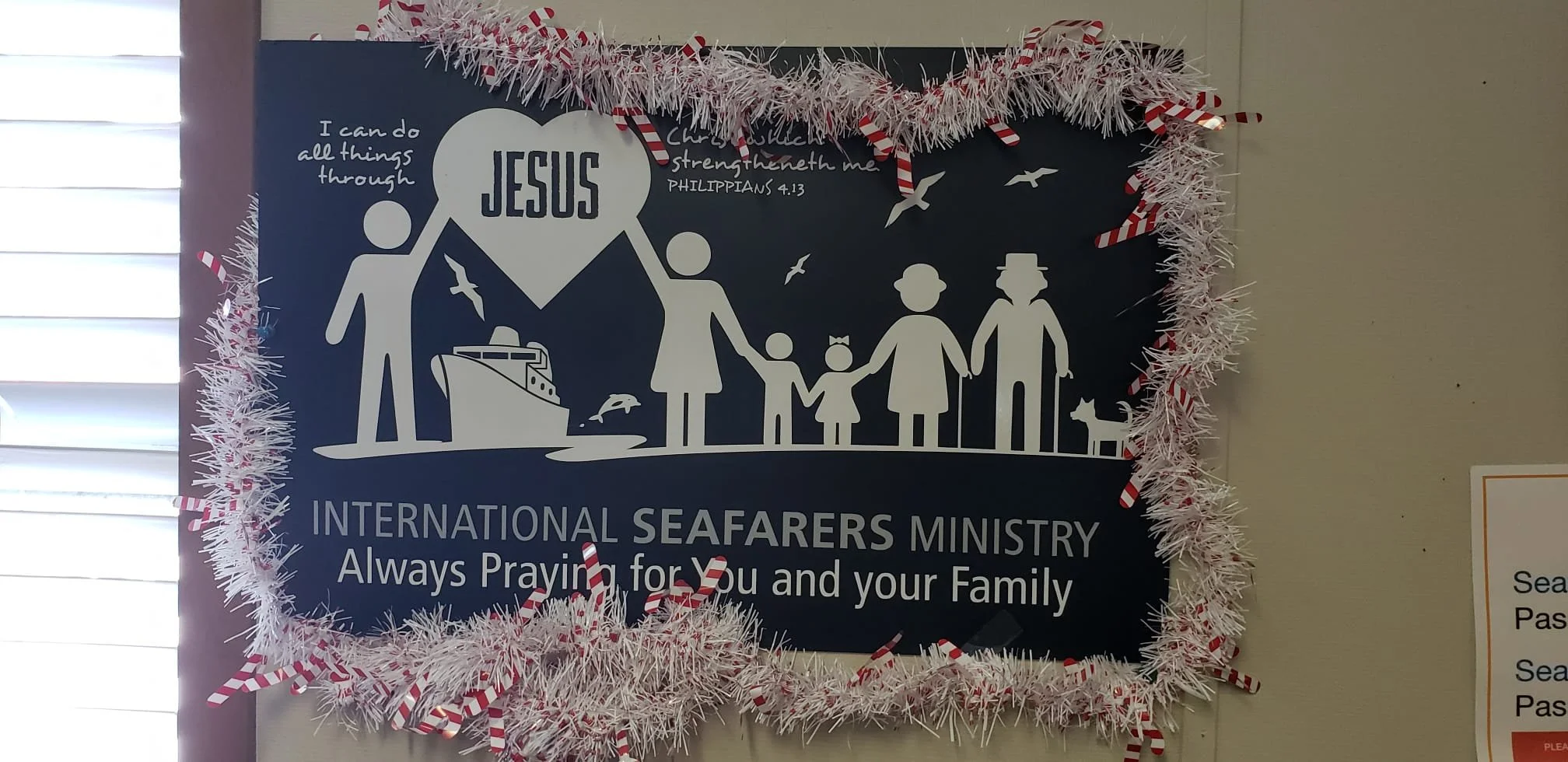 Decorated poster for International Seafarers Ministry with a family graphic and the words 'Always Praying for You and Your Family', surrounded by Christmas garland.