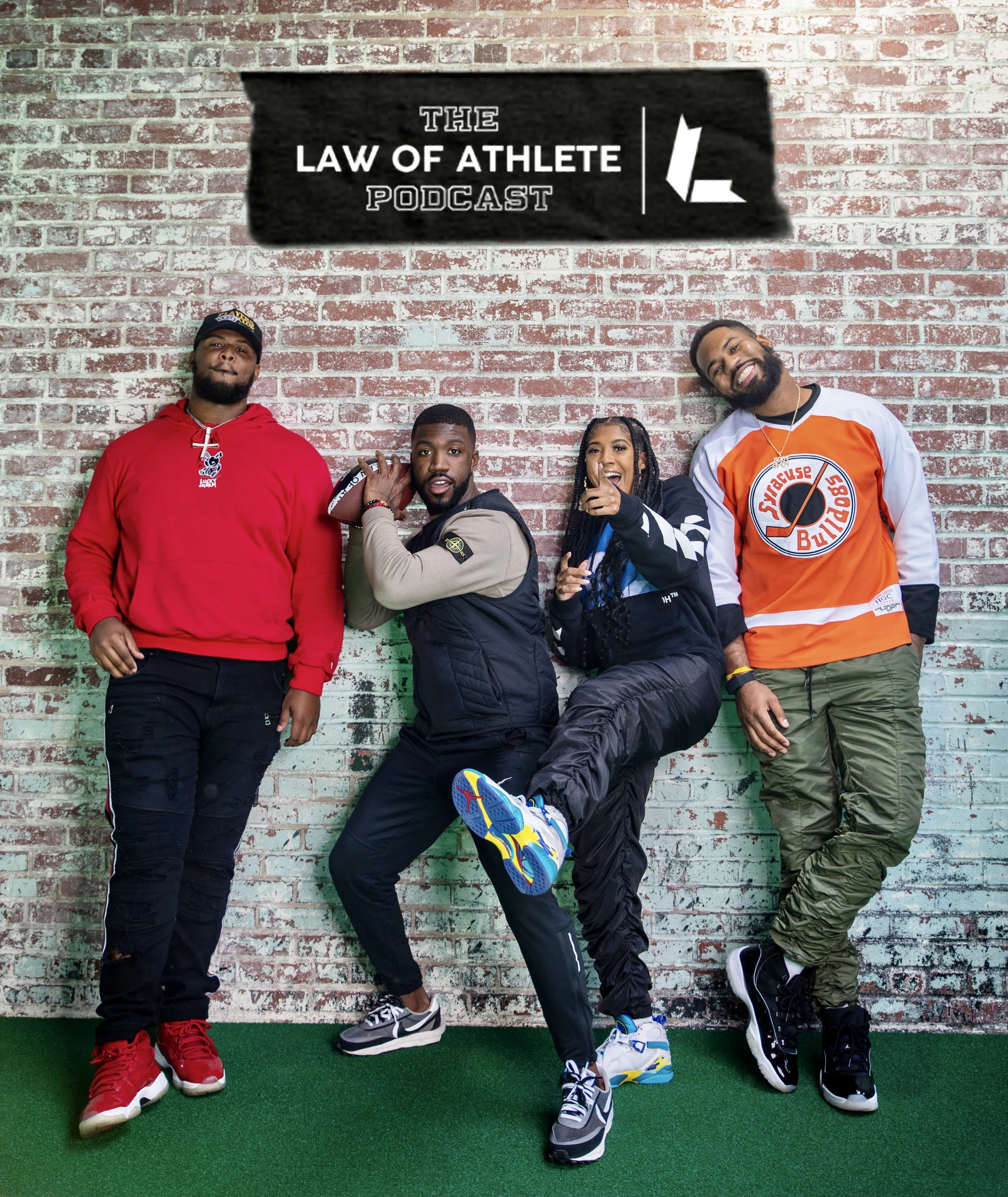 Four diverse people standing against a brick wall, posing for a photo, with a sign above them that reads 'The Law of Athlete Podcast.'