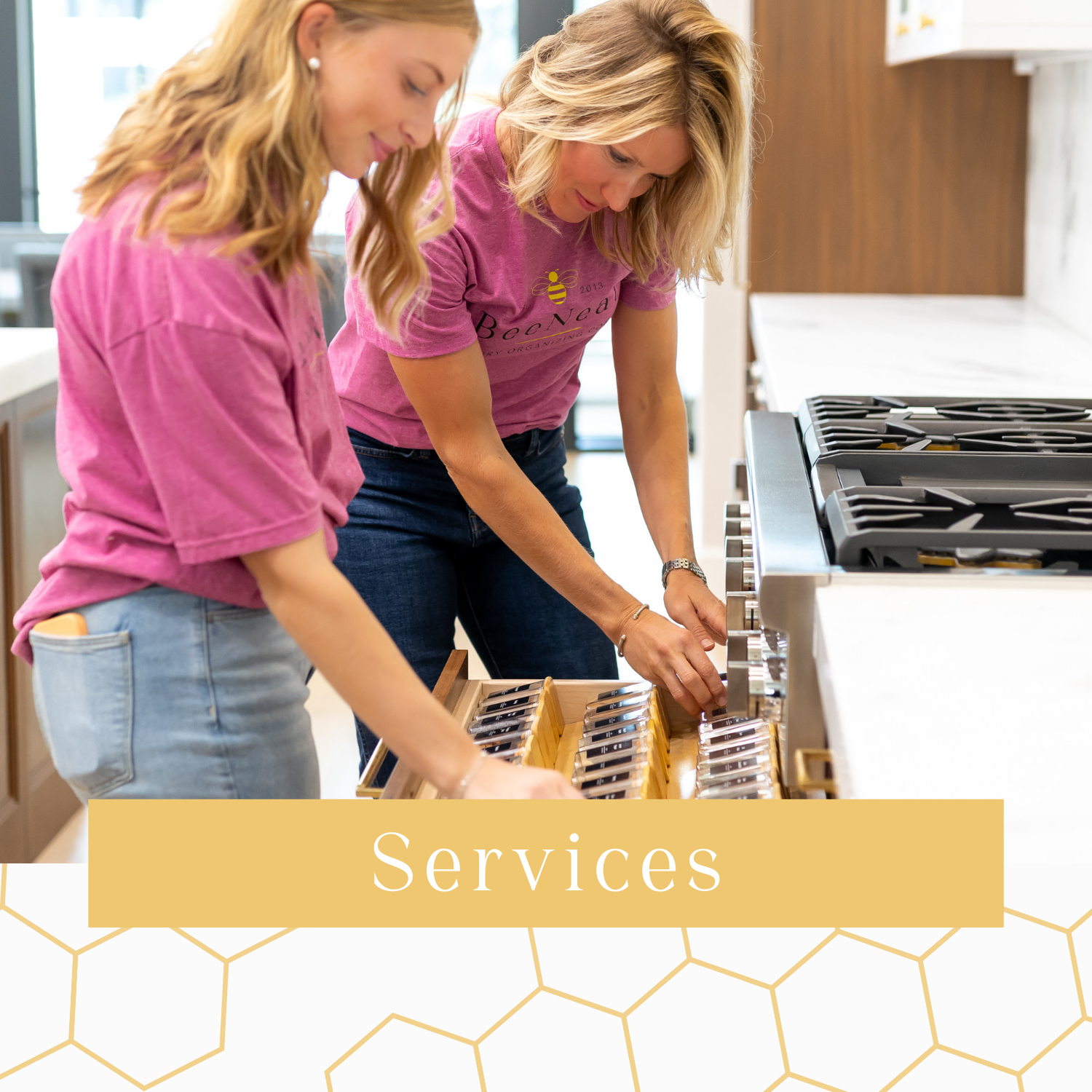 2 organizers in pink shirts organizing a kitchen drawer