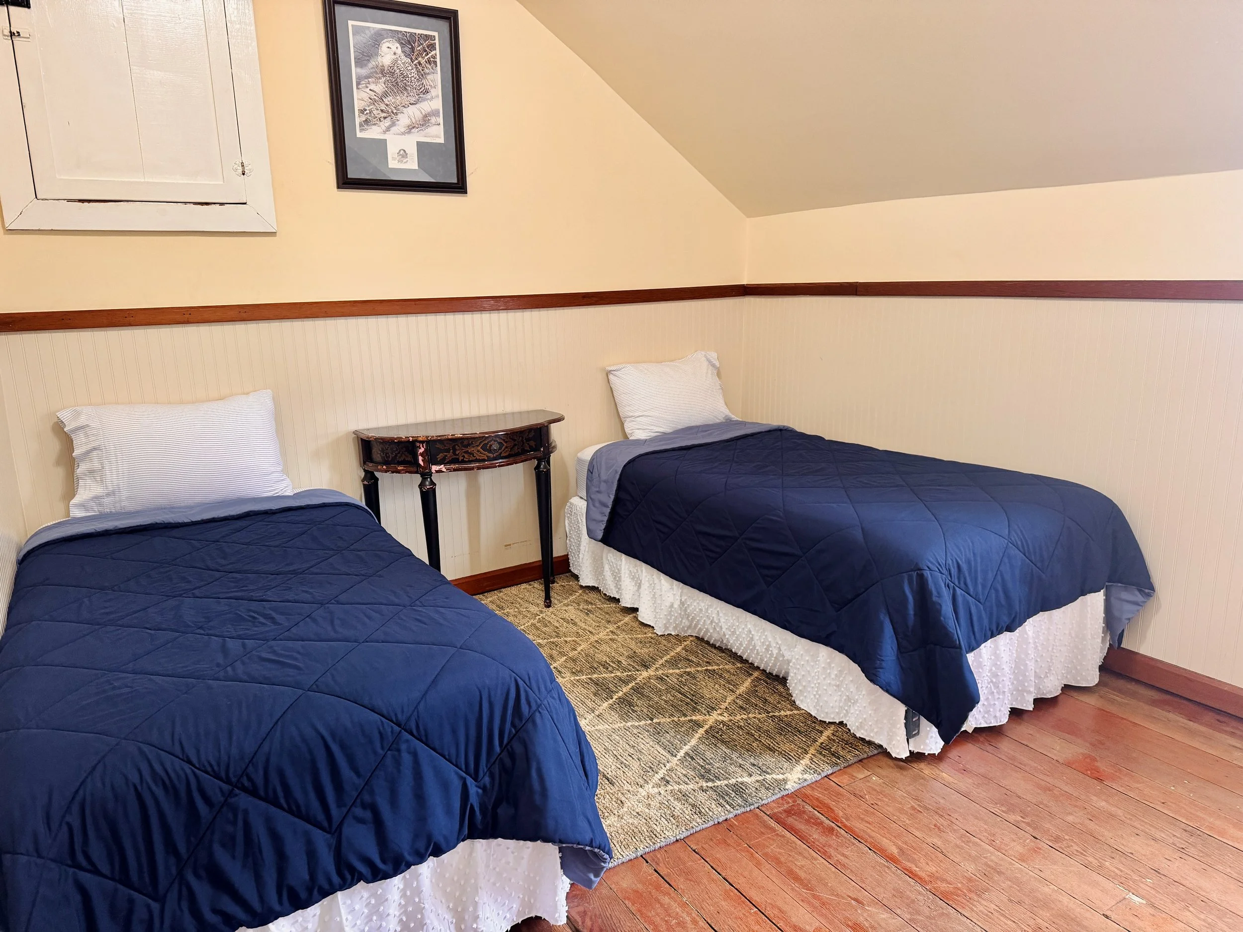 Bedroom #6 - The Sitka Spruce Room - features two twin beds and a view of the ocean