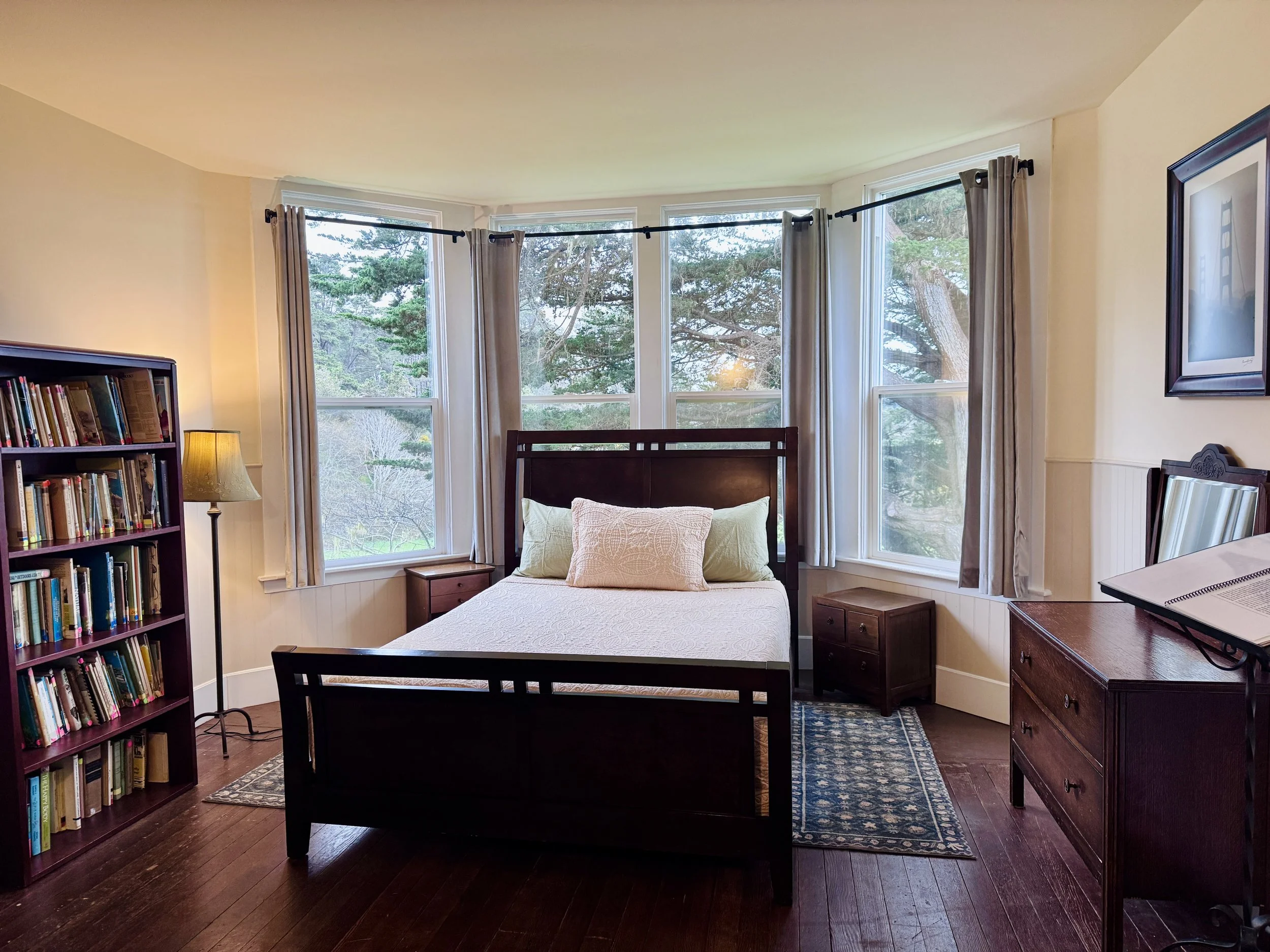 Bedroom #1 - Located Downstairs, this bedroom features a Queen sized bed, an en suite bathroom, and direct access through the bathroom to the back deck.  Windows look directly at the largest Cypress tree on the Jug Handle property. 