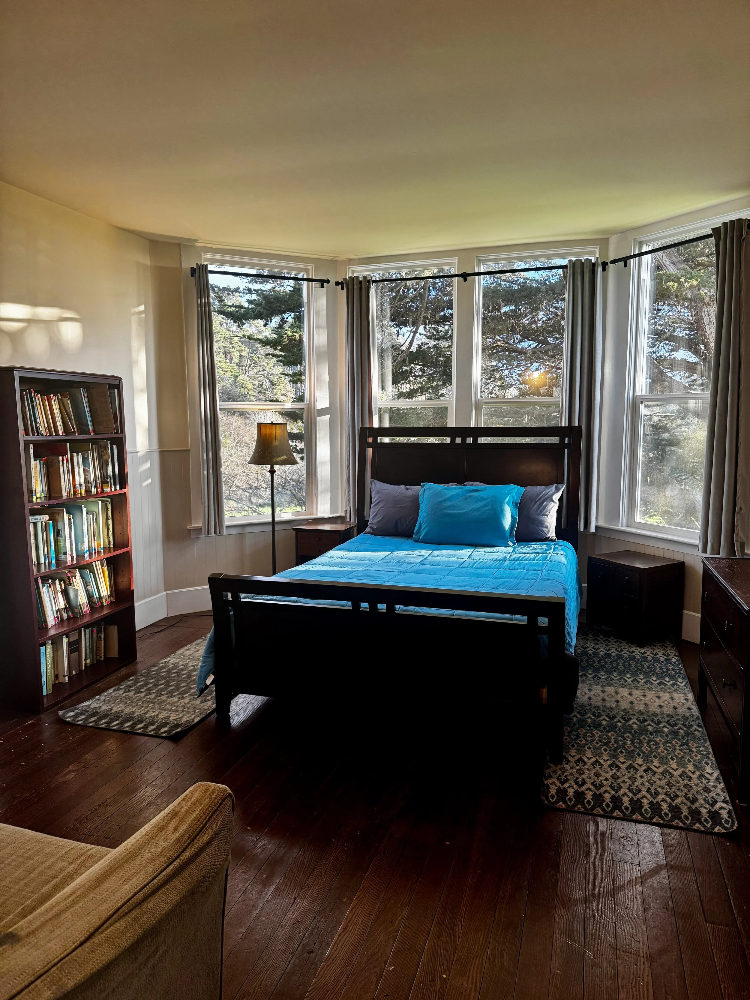 Bedroom #1 - Located Downstairs, this bedroom features a Queen sized bed, an en suite bathroom, and direct access through the bathroom to the back deck.  Windows look directly at the largest Cypress tree on the Jug Handle property. 