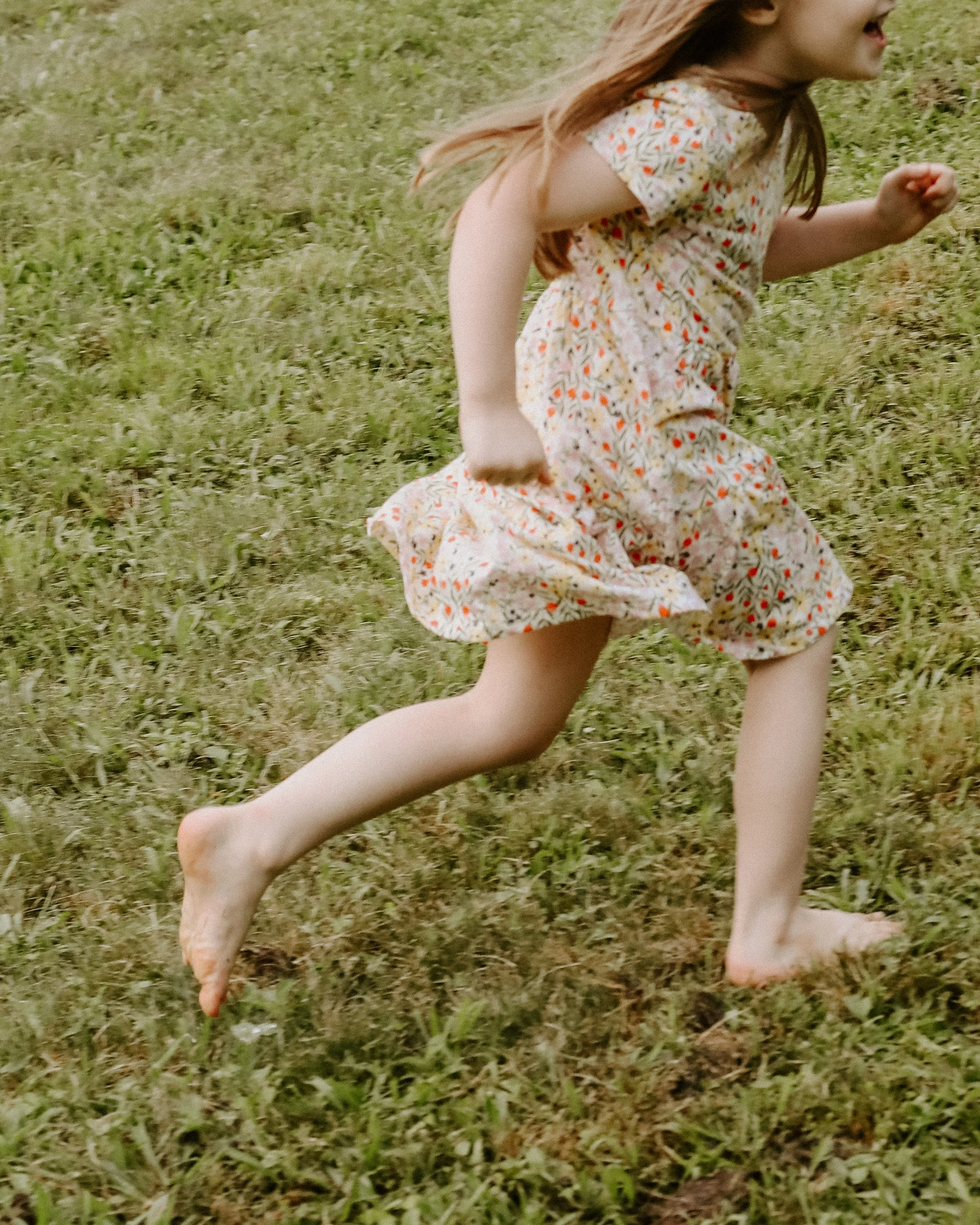 little girl running through grass