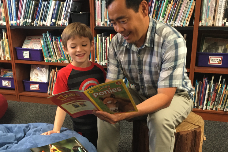 ��������-head-of-school-donny-kim-reading-to-student-in-library.png