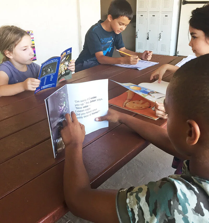 four-ɫTV-elementary-school-students-reading-books-at-table.jpg