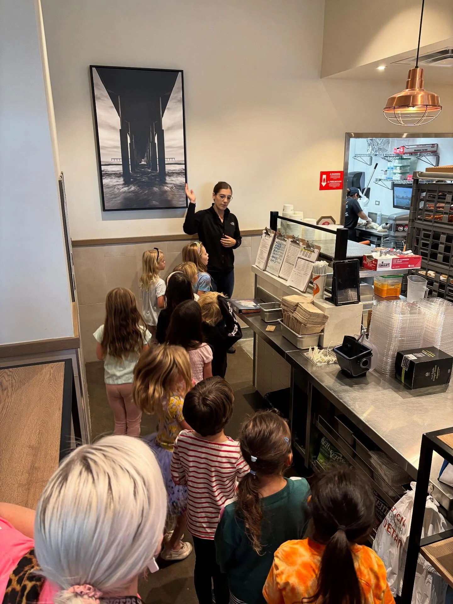 1st grade post for Monday, Melissa lemme know if this is good! 

First Grade Field Trip to Urbane Cafe! 🥗🍽️

After being given the title of Jr. Baker, the students got a tour of the restaurant including the back kitchen and the walk-in fridge and g