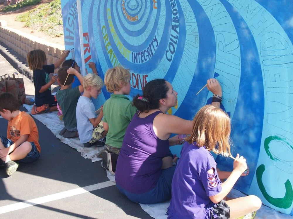 ��������-children-and-teacher-painting-mural-about-school-values.jpeg
