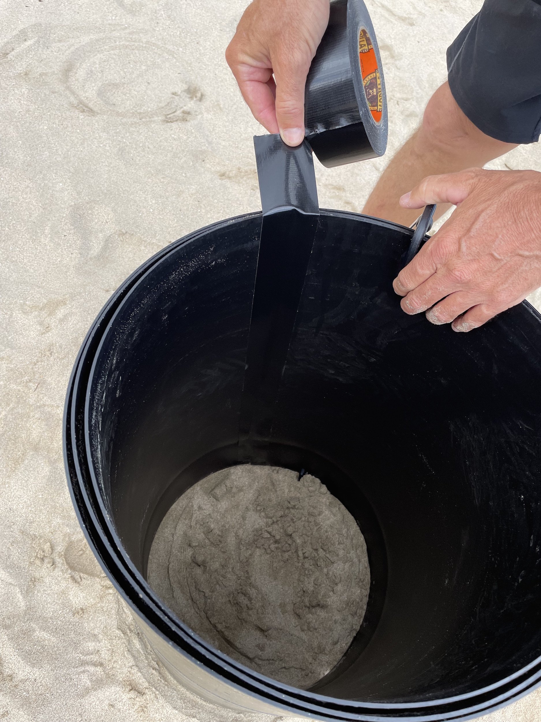 create a sand sculpture using a plastic form at the beach