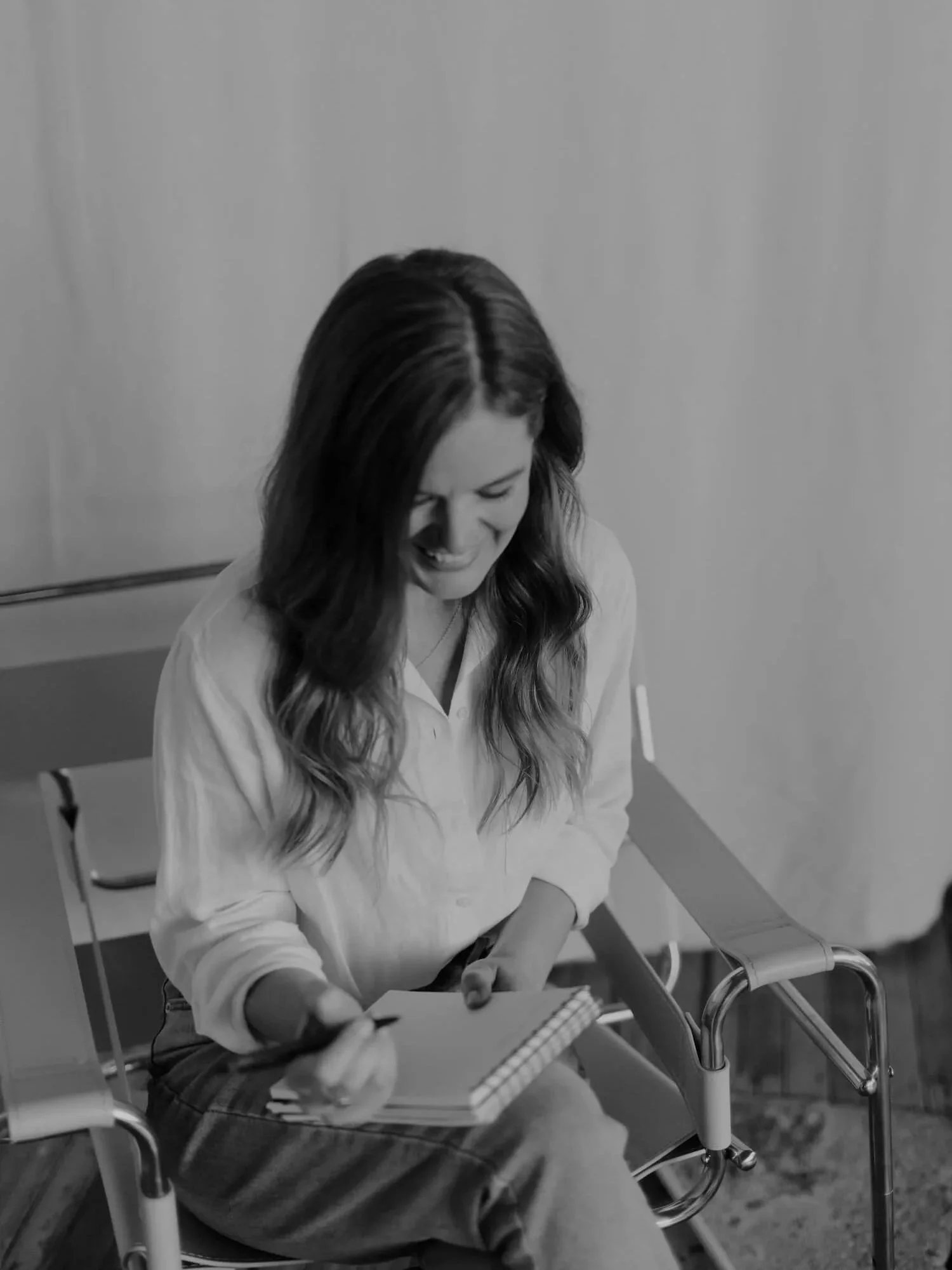 Alana Jade, Squarespace SEO expert, smiling and writing in a notebook