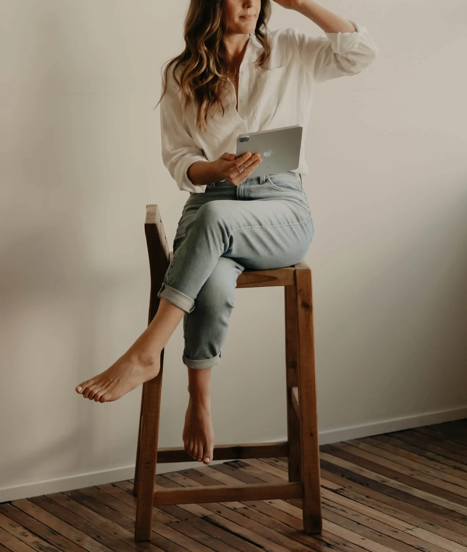 Alana Jade, Squarespace web designer and Squarespace SEO specialist, seated holding an iPad