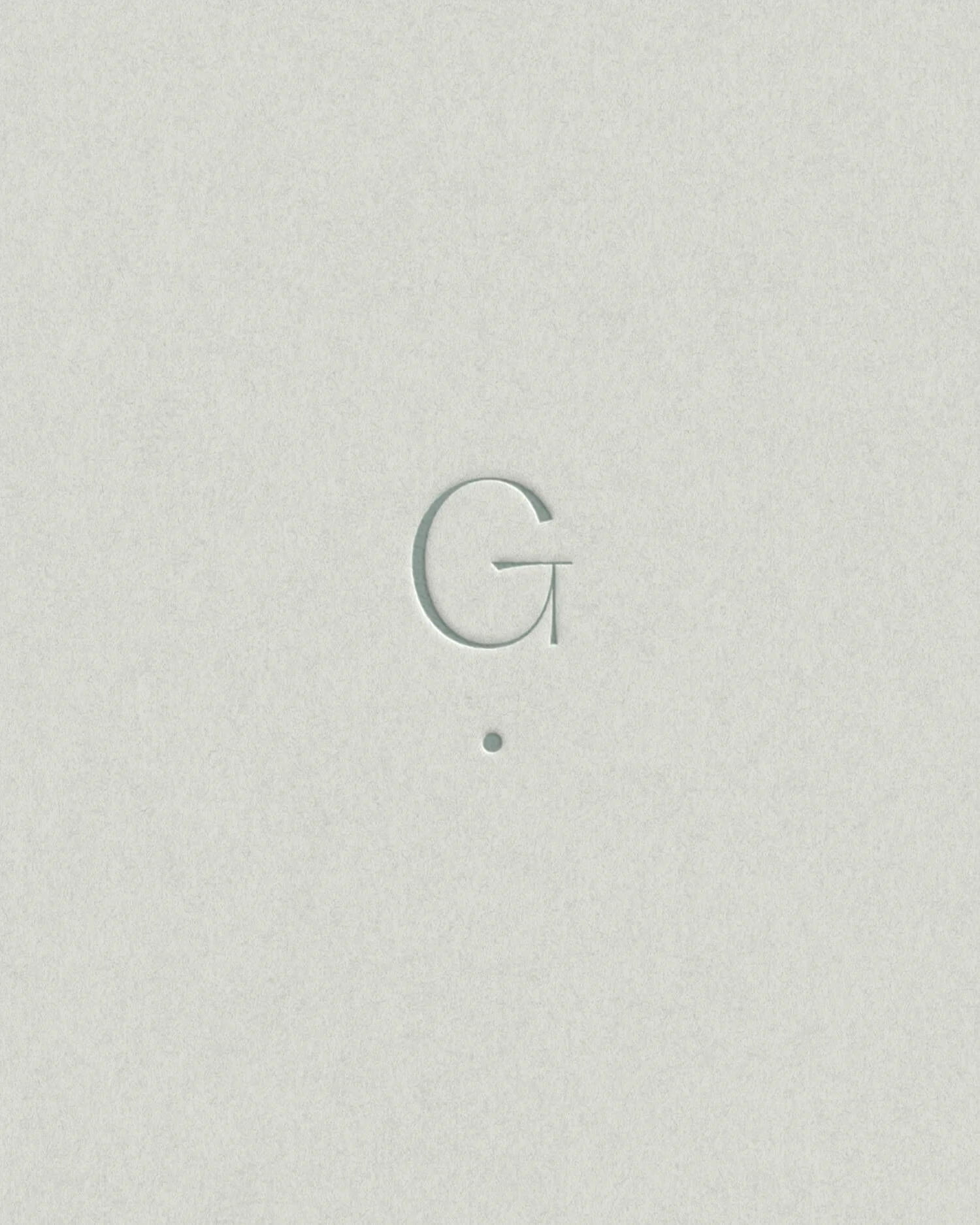 Minimal embossed “G” brand mark on textured paper, part of a brand identity for a somatic psychotherapist in Brisbane.
