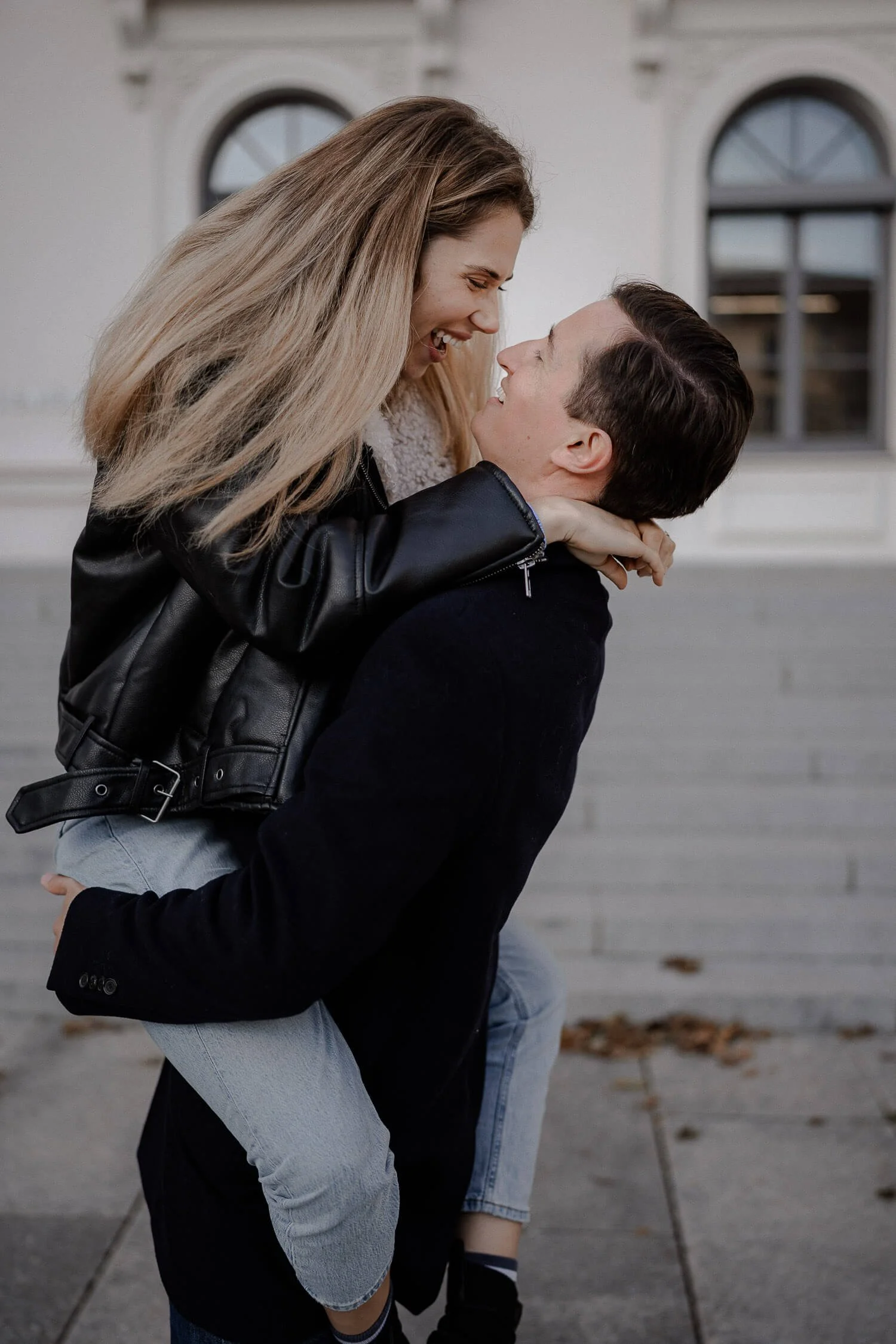 Couple shoot Munich mit lachendem Paar vor hellem Gebäude